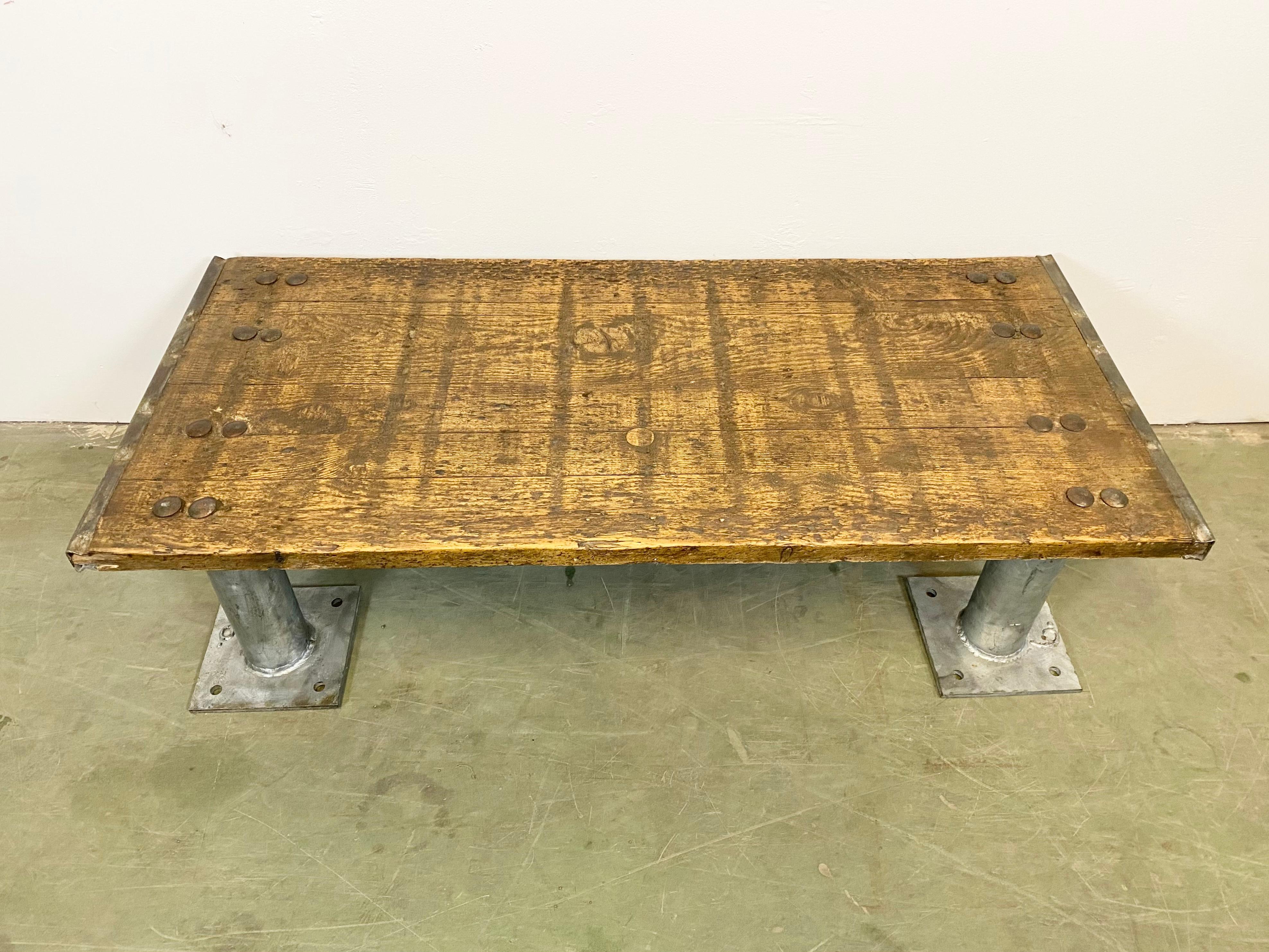 Industrial coffee table. It features iron legs and old wooden plate with very nice patina. Weight 51 kg.