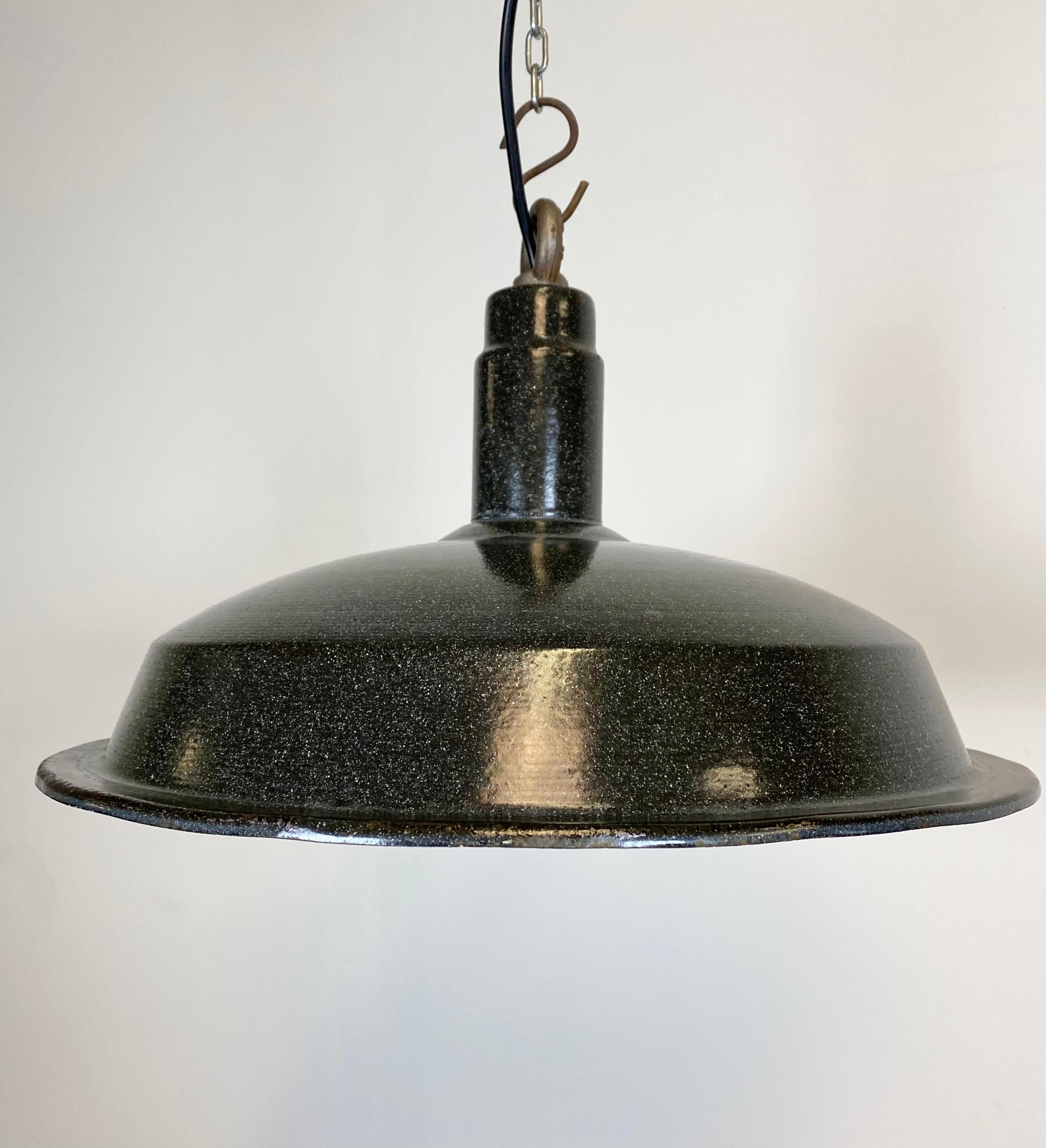 Industrial hanging light made in the 1950s. Dark grey enamel. White interior. Iron top. New porcelain socket for E 27 lightbulbs and wire. Weight: 2 kg. Measure: Diameter 42 cm.