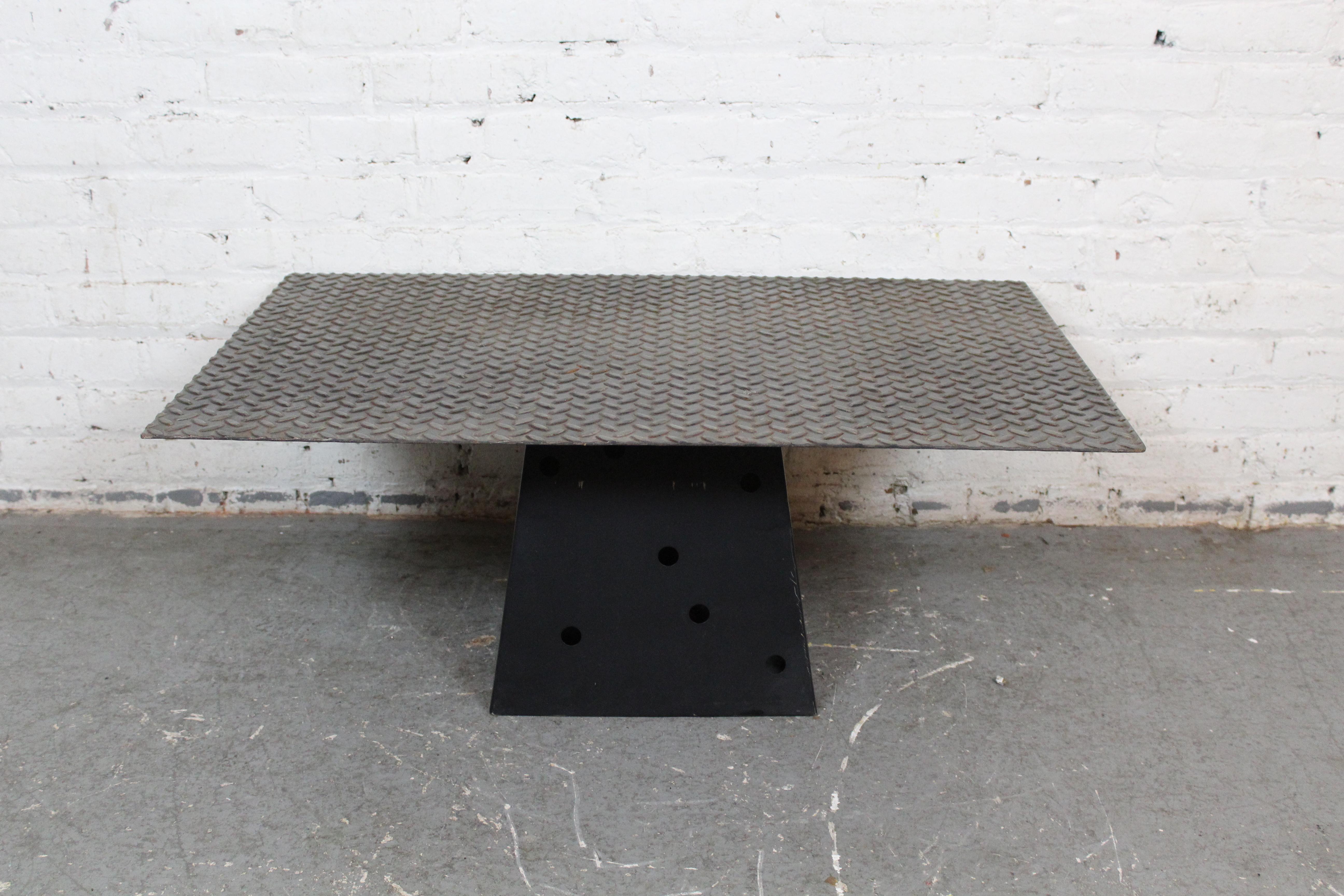 Stellen Sie Ihre Wohnungseinrichtung auf ein Podest mit diesem ausgefallenen Couchtisch aus Metall! Eine große Platte aus diamantbeschichtetem Stahl bildet eine robuste Tischplatte (über 6 Quadratmeter groß!)  die auf einen pyramidenförmigen Sockel