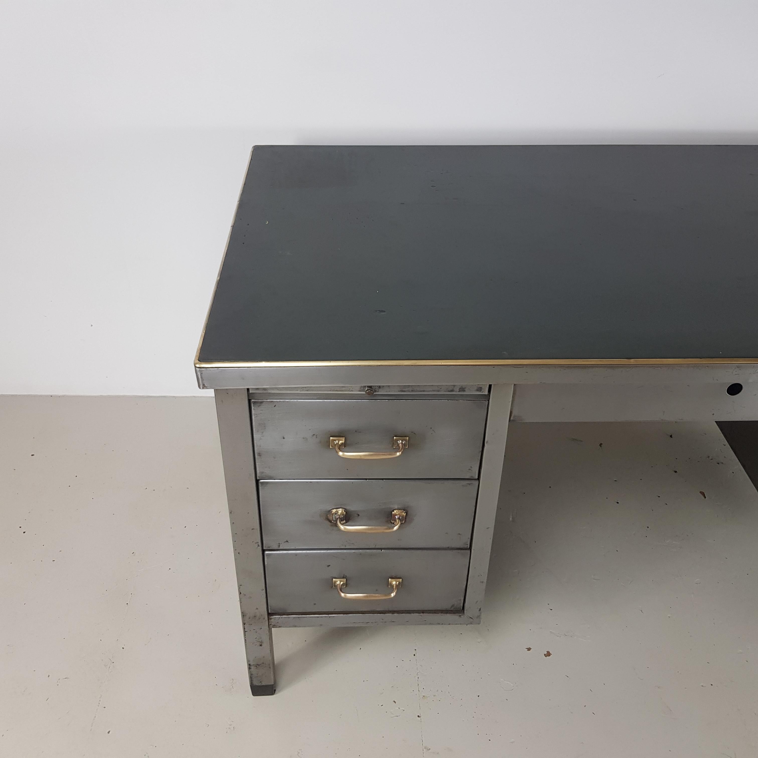 Lovely vintage double pedestal polished steel desk.

In good vintage condition - this piece comes from a working Industrial environment and as such, has signs of wear and tear commensurate with age i.e bumps, scuffs etc, all adding to the