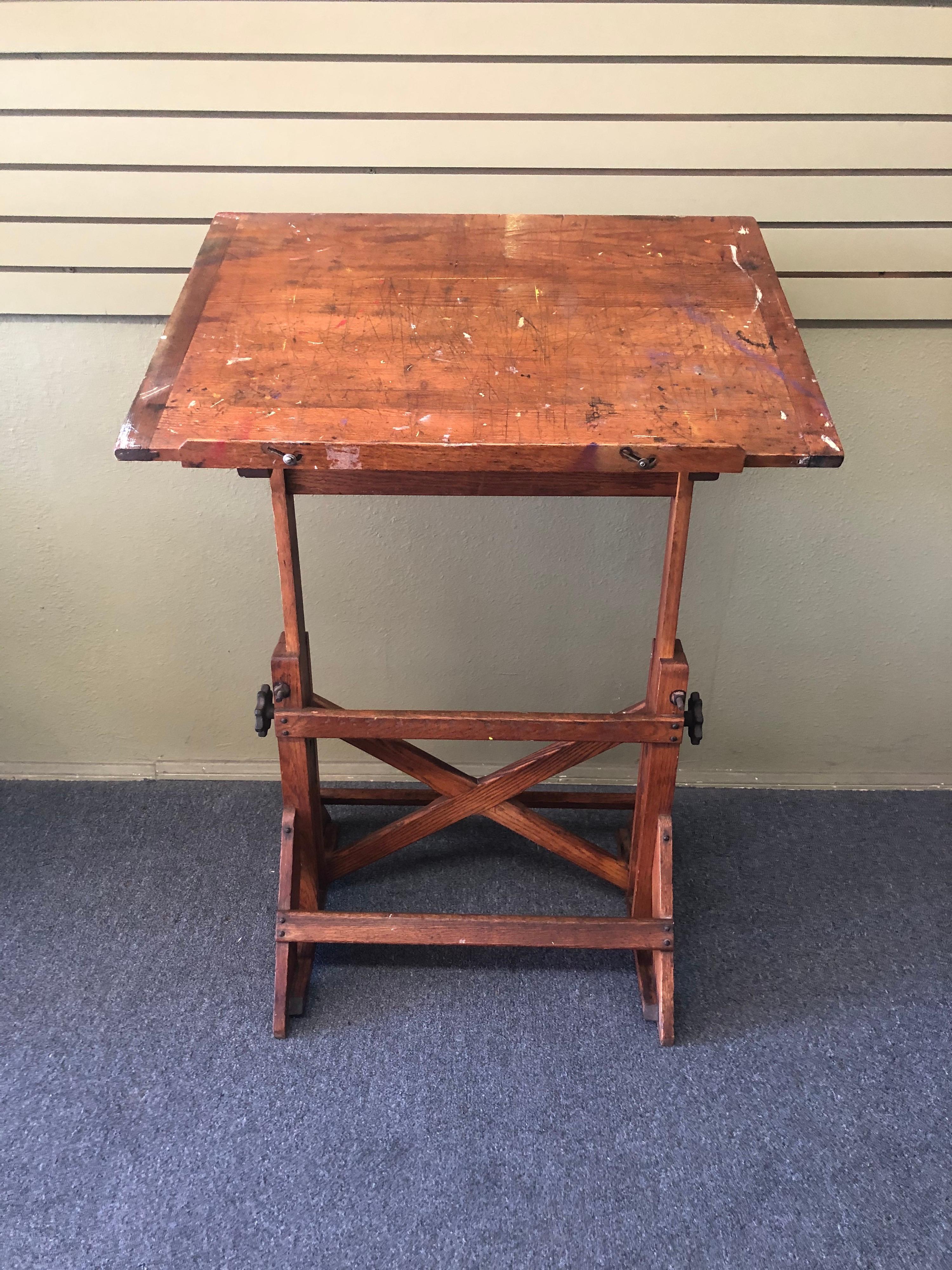 Wonderful vintage industrial drafting table or desk by The F. Weber Co. of Philadelphia, circa 1940s. Table features a beautifully crafted oak base with aged cast iron hardware. Height and angle are fully adjustable. A great, versatile size that can