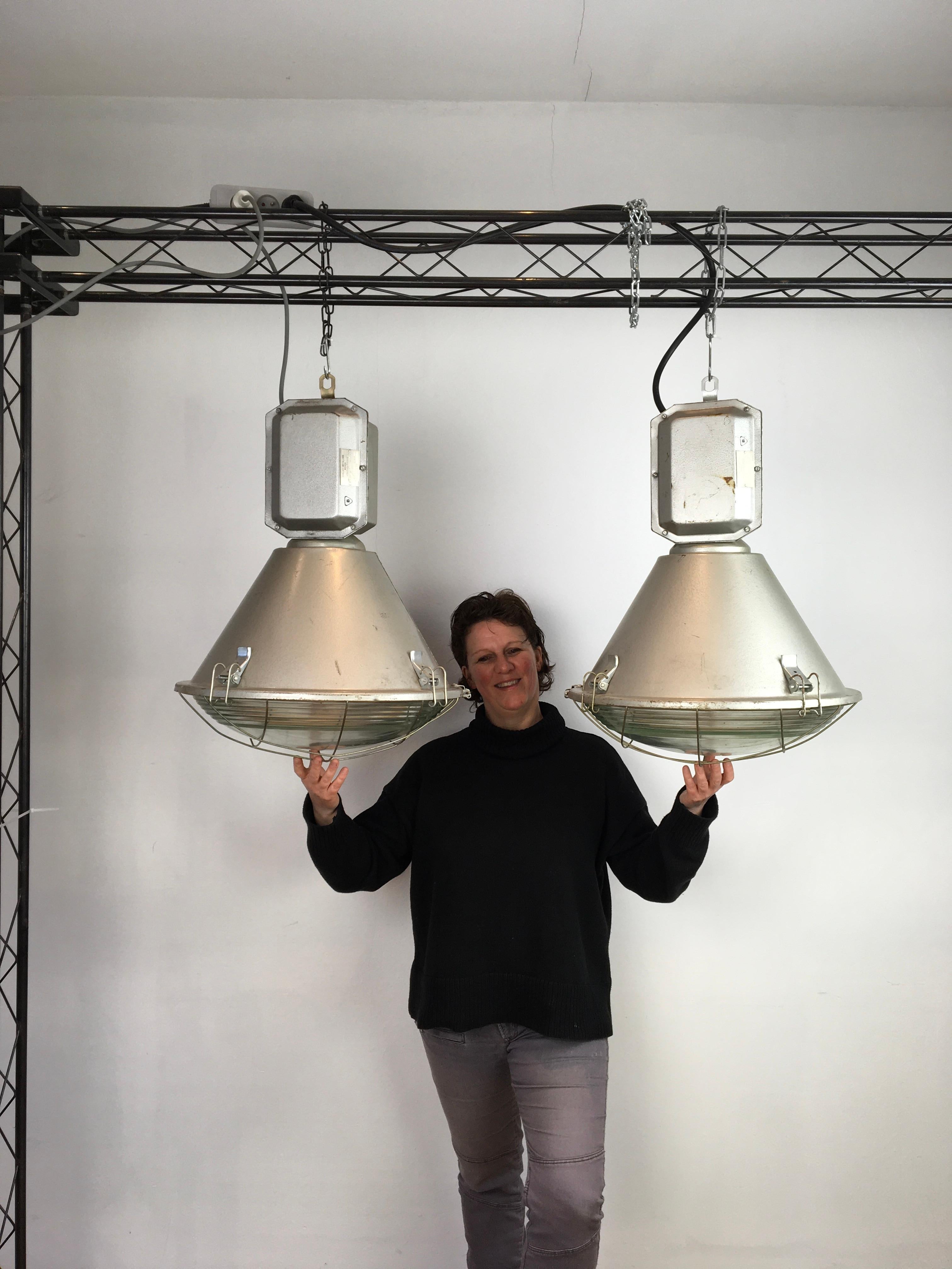 Vintage industrial factory lights. 
Large industrial lamps with a convex glass and a metal grill. 
They date from 1994 and were made by the Zaklady Metalowe Mesko w Skarzysku - Kamiennej - Poland. 

These large grey factory lighting will look great