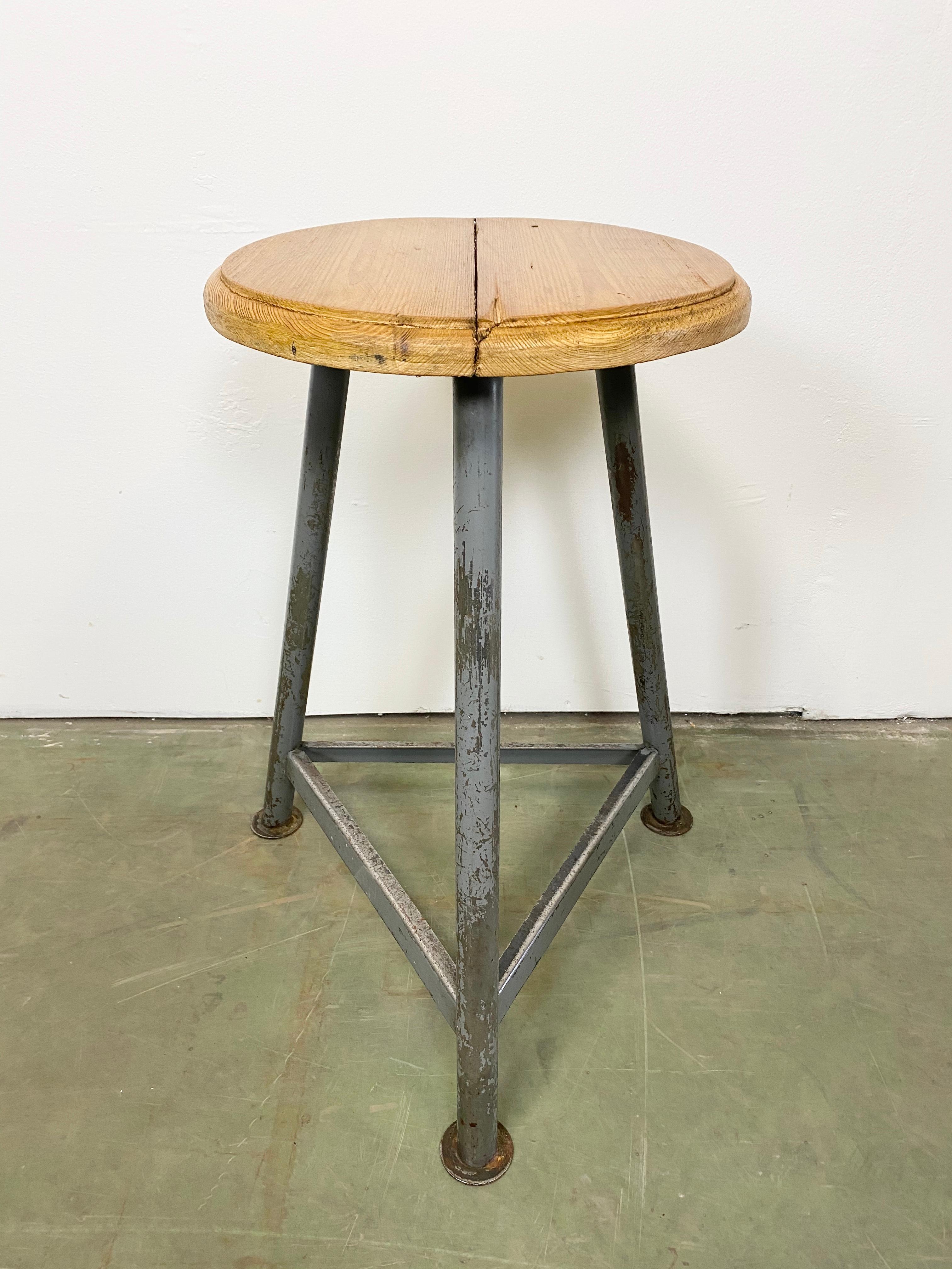 Industrial stool with a wooden seat and grey metal frame.
The weight of the stool is 5 kg.