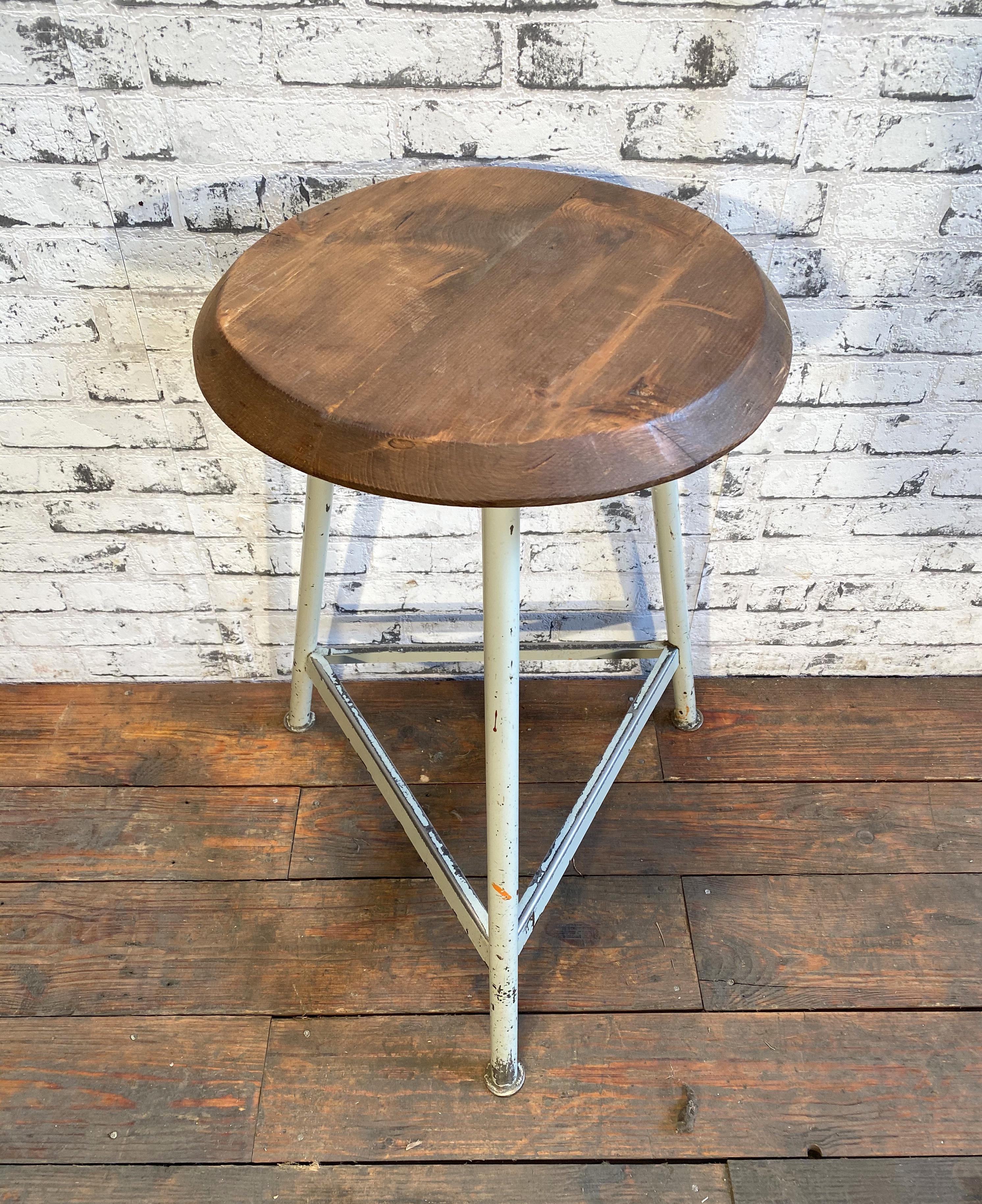 Industrial stool with a wooden seat and white metal frame.