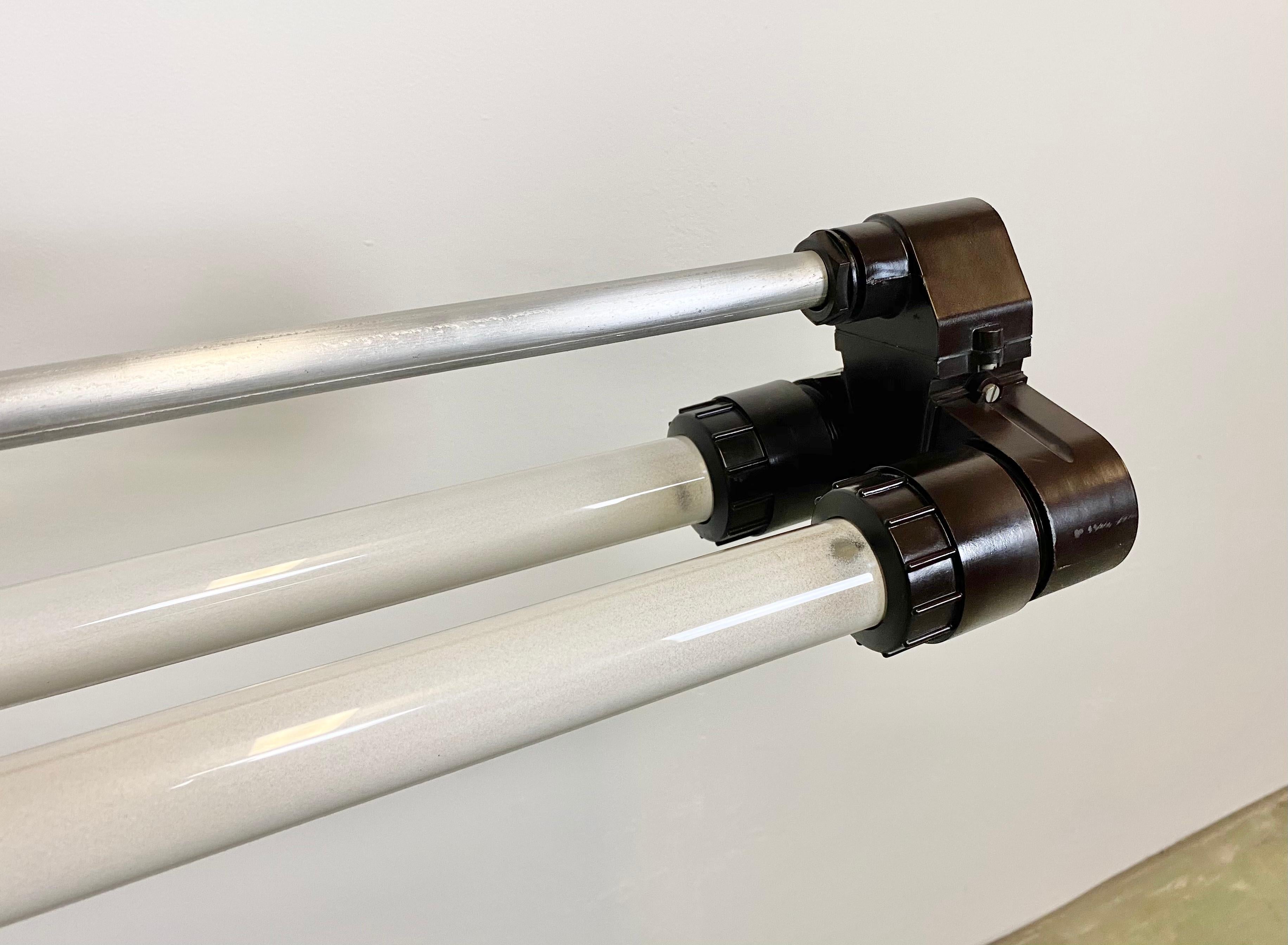This industrial cast aluminium and Bakelite fluorescent light was made during the 1970s in former Czechoslovakia. These fixtures were used in laboratories and chemical and industrial plants. The light requires two T8, 150 cm fluorescent tubes. The