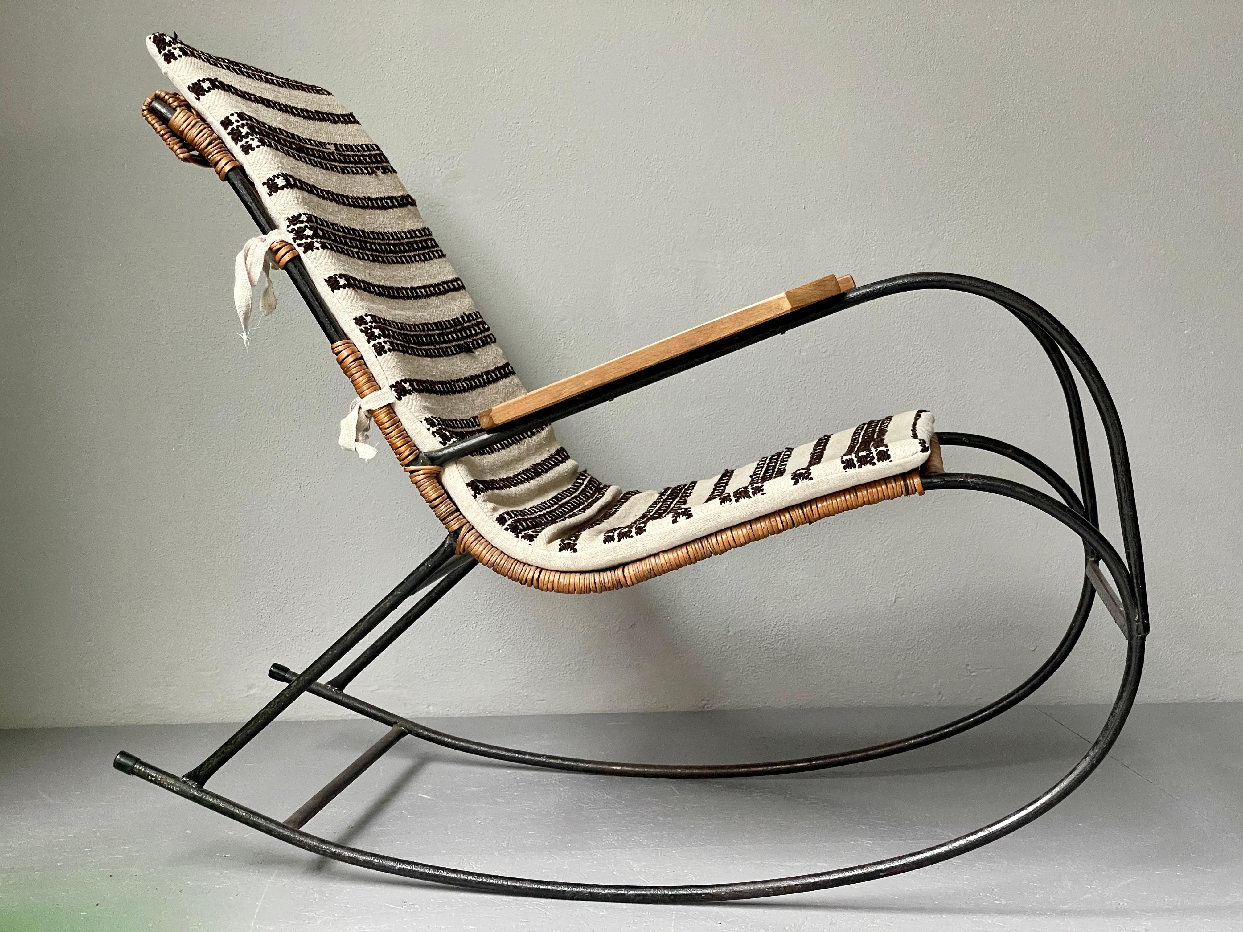 Mid-Century iron & wicker rocking chair with beautiful lines and a comfortable seat. The cushion has been tailor made with vintage fabric from Hungary. This is truly a unique piece, designer unknown.