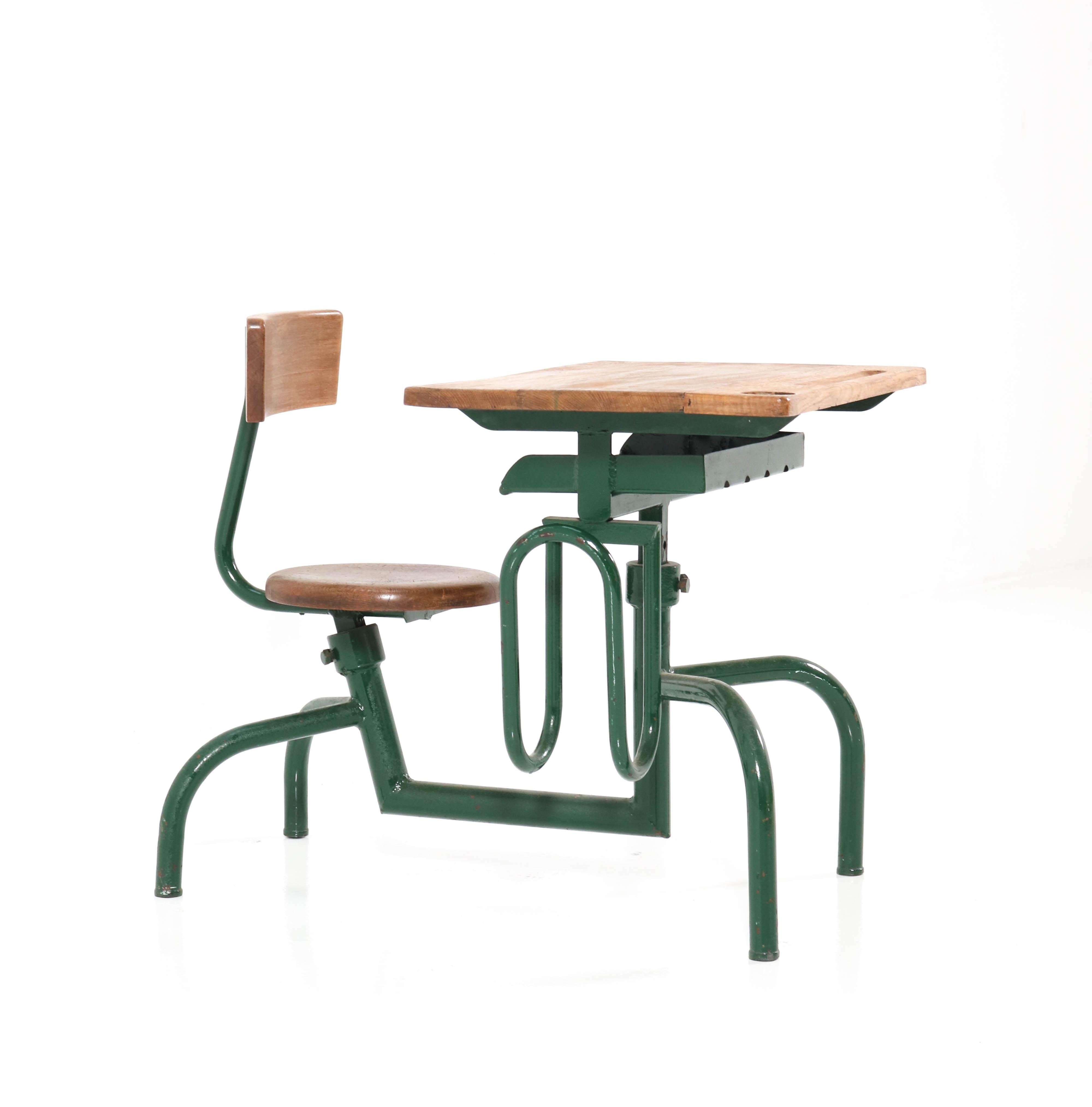 Wonderful Vintage Industrial school desk.
In the style of Jean Prouvé
Striking French design from the 1950s /60s.
Green lacquered metal base with original solid oak top and seat.
In very good condition with a beautiful patina.

 