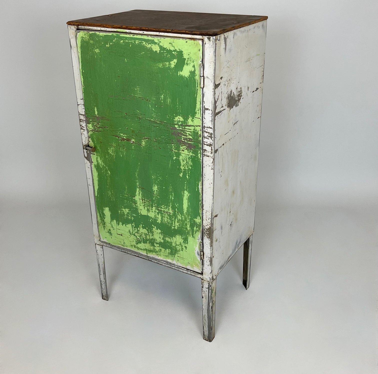 Vintage industrial metal cabinet with original paint was saved from a factory in former Czechoslovakia. The piece has been cleaned thoroughly. The wooden shelves inside are newly made form recycled wood. 
It will add uniqueness to any interior.