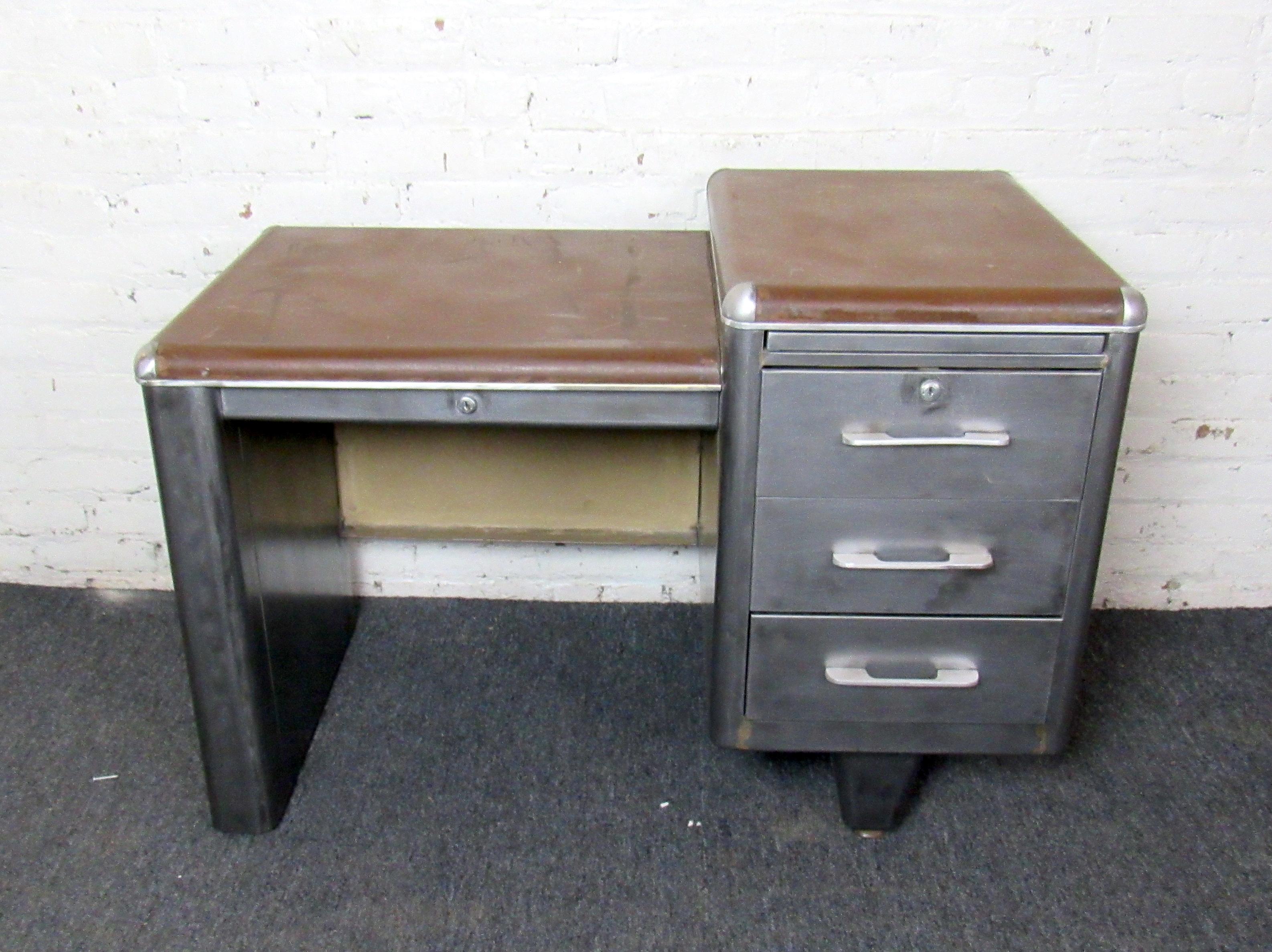 A vintage industrial-style metal desk that is sure to add rugged character to any office, garage, or shop. Three large drawers on the right side of the desk allow for plenty of storage while the top of the desk makes for a smooth writing surface.