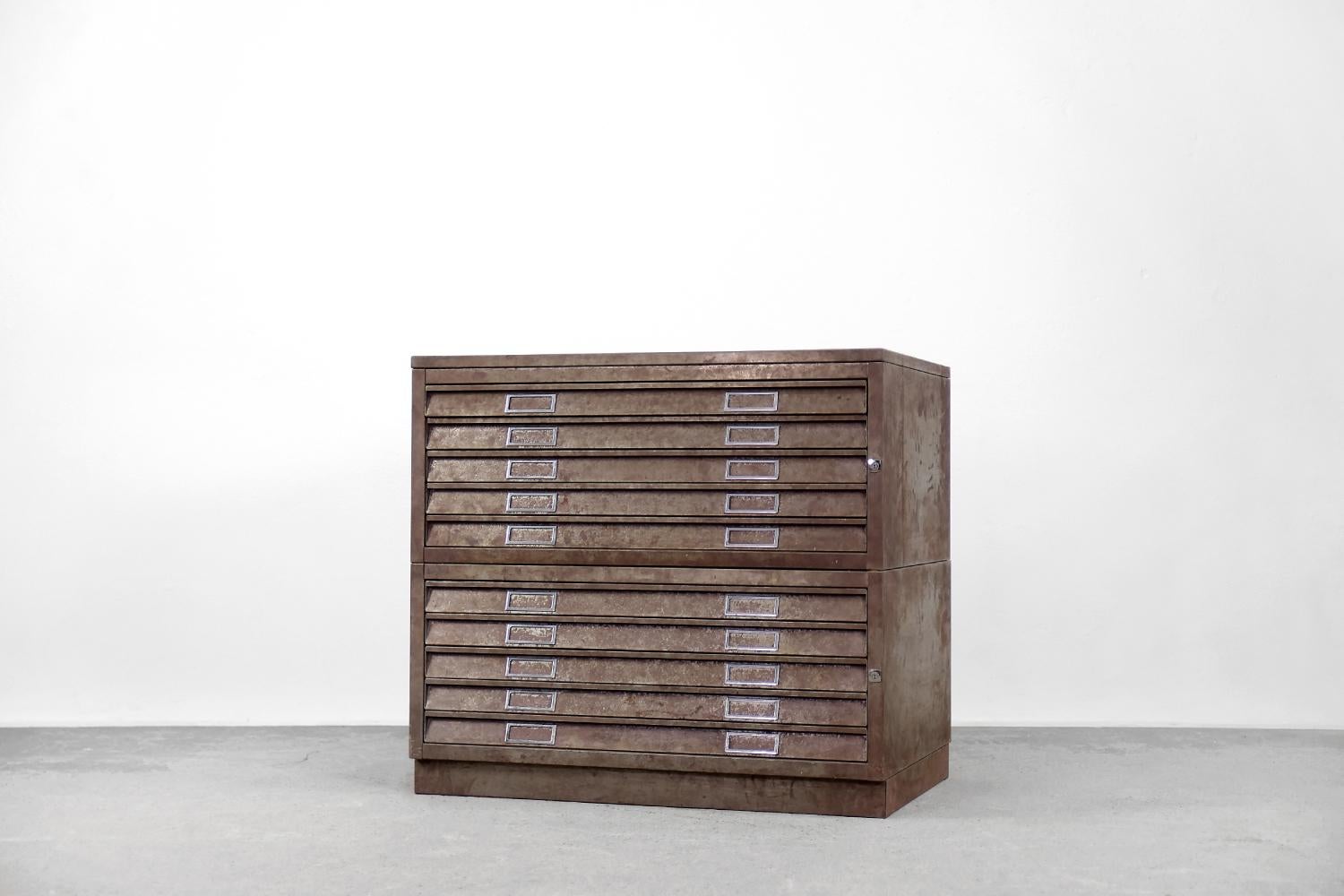 This modular cabinet was made during the 1970s. Consists of two pieces, stacked on top of each other, and a separate base. Each module has five flat drawers. The cabinet is entirely made of metal. It is ideal for storing oversized materials,