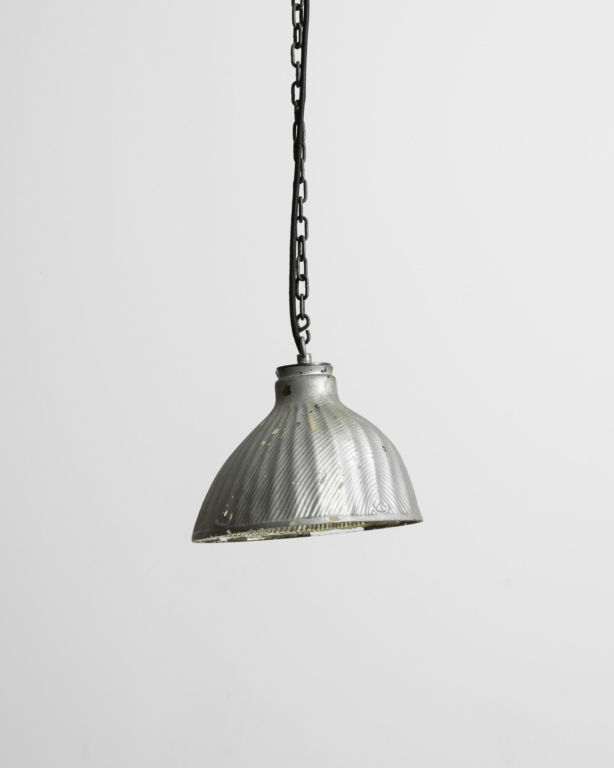 This turn of the century pendant lamp offers a unique industrial accent. The asymmetrical shape and subtle fluting of the shade create a streamlined yet organic design; the rippled texture of the surface evokes the ridges of a human fingerprint.