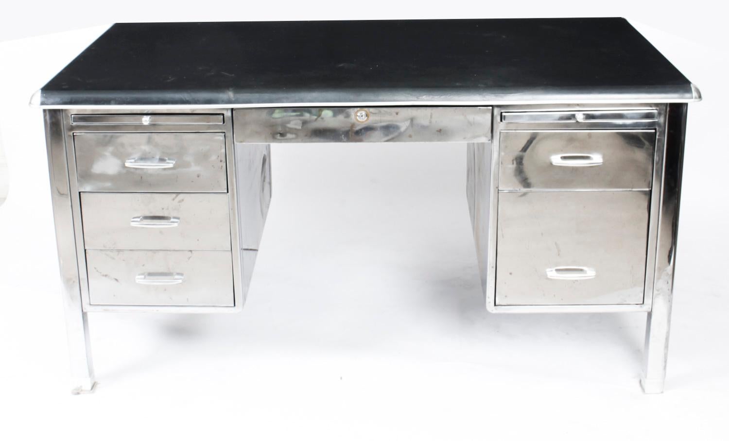 This is a large vintage Industrial Modernist polished steel pedestal desk, dating from Circa 1950 and made by Cubacier in Brussels, Belgium.

The rectangular top features an inset black writing surface above a frieze draw in the center with a