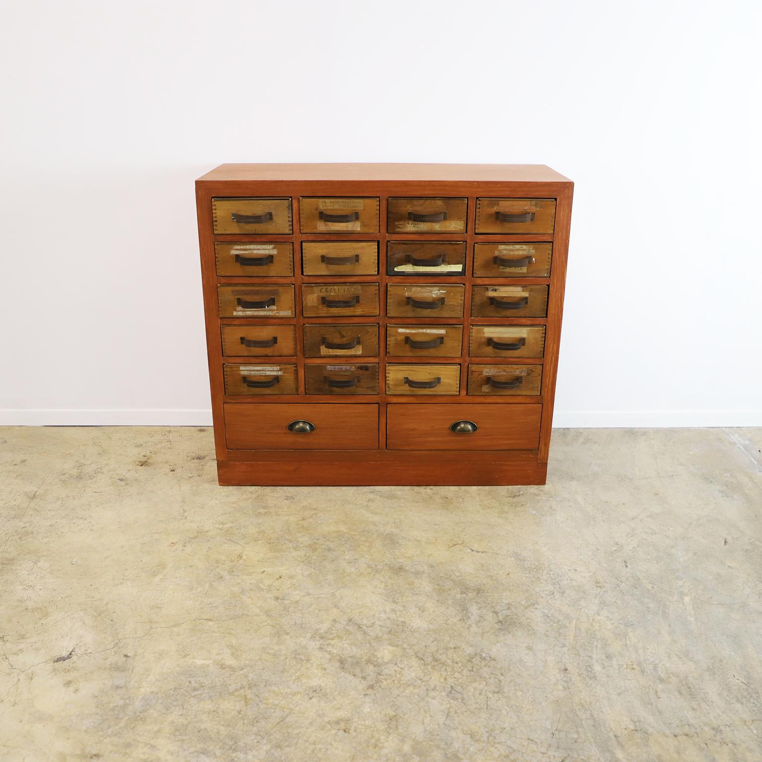 Circa 1960. We offer this Distressed Multi-Drawer Wooden Storage Cabinet with 22 Drawers