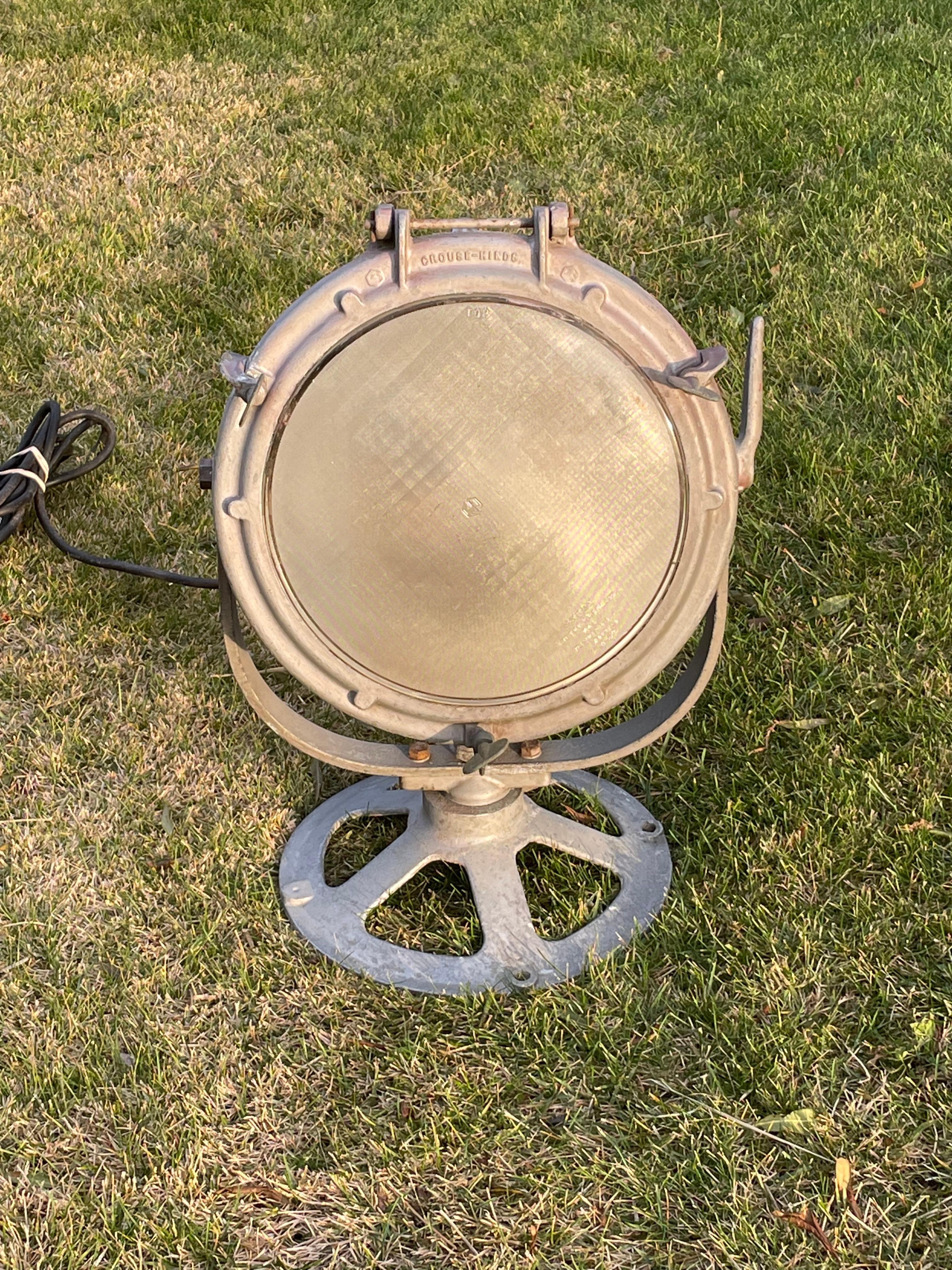 Foco o reflector náutico industrial vintage de Crouse Hinds, con una pantalla de cristal Pyrex que se abre fácilmente para cambiar la bombilla. El cabezal grande gira y se inclina en la dirección deseada. Tiene un asa para transportarlo . Alrededor