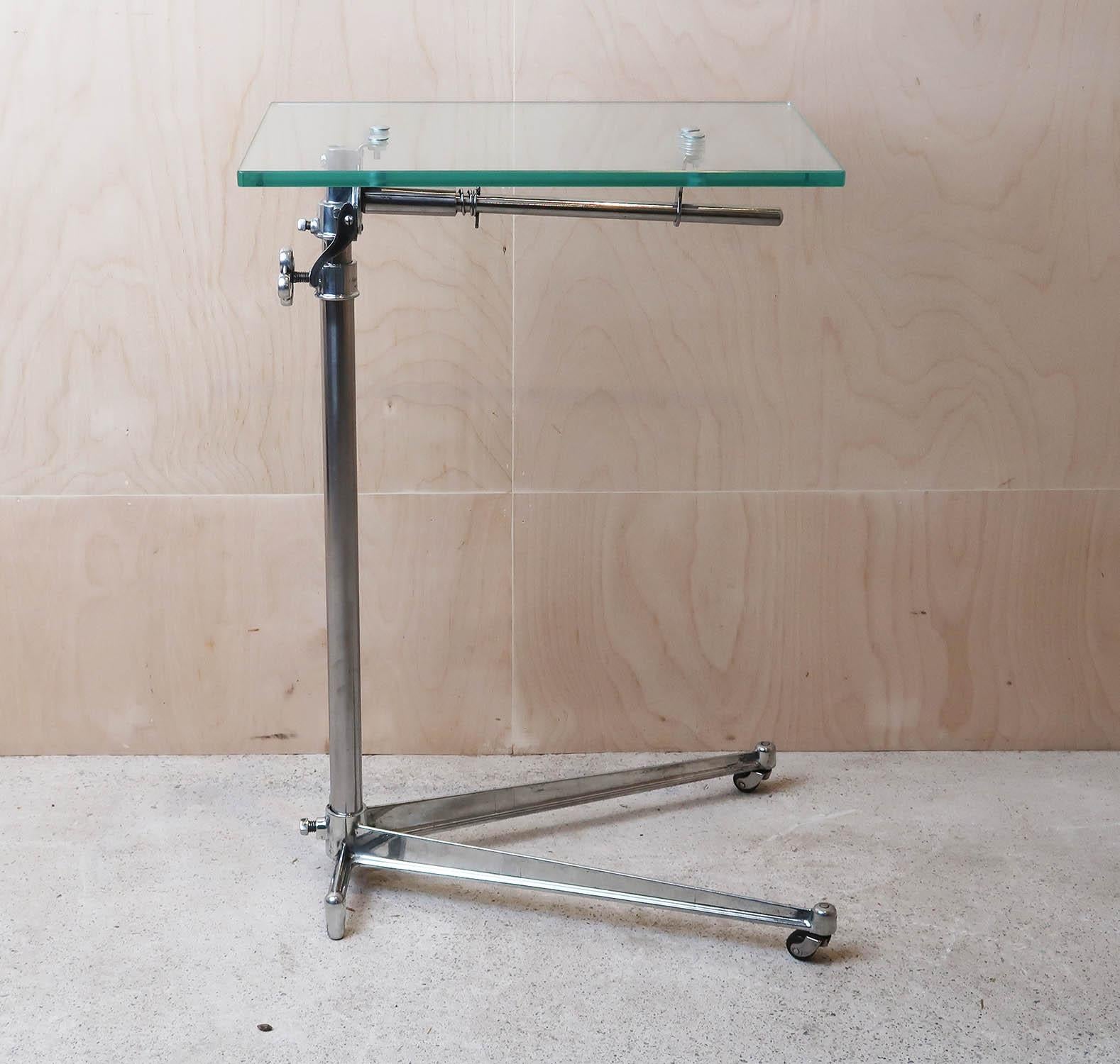 Stylish side or work table with an elegant Industrial look.

Made of polished steel with a new toughened glass top.

The top is adjustable by loosening the handle on the side.

The top can also be tilted.

On the original pot castors it can be