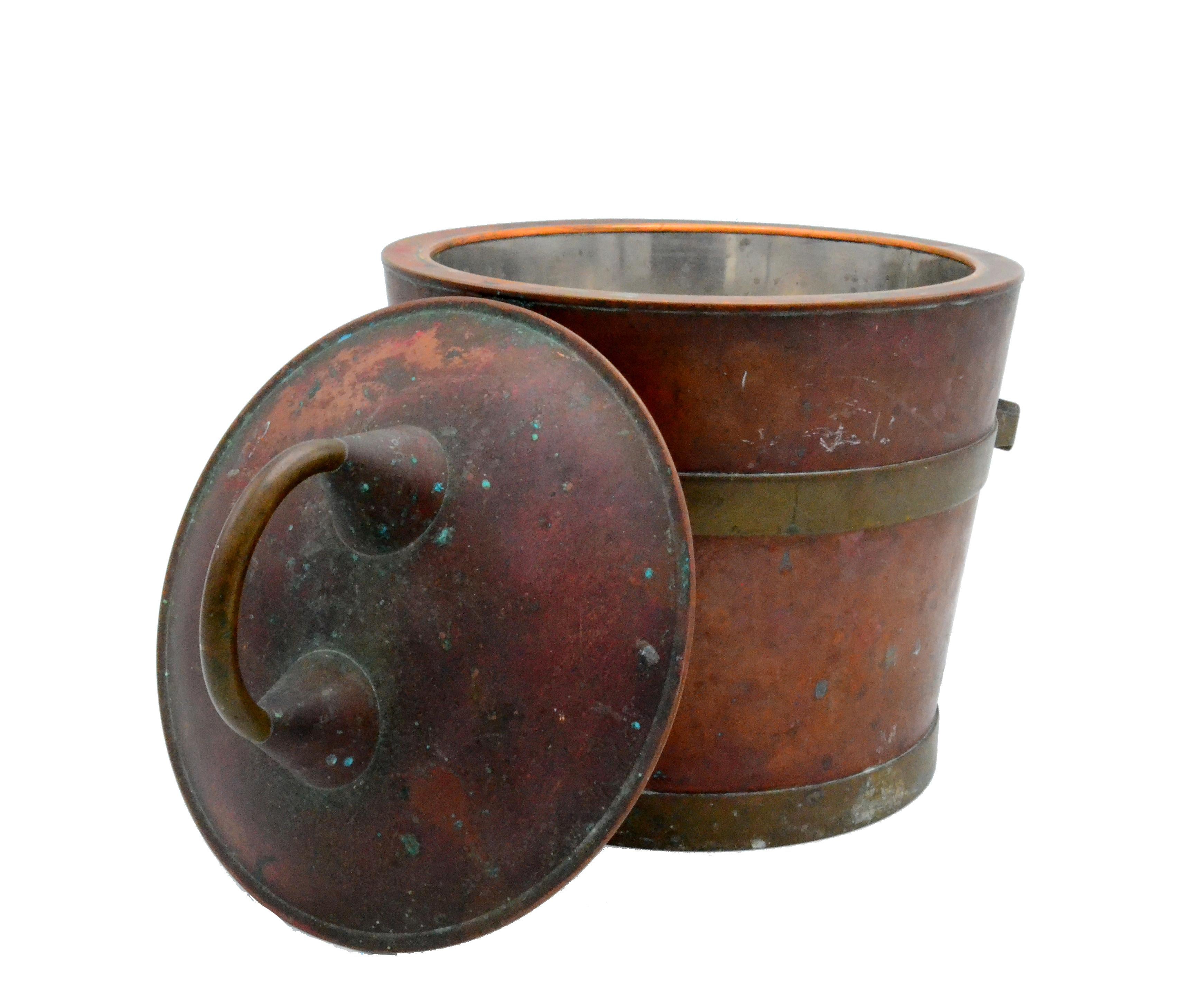 A J.C. Industrial, rustic handmade ice bucket with a copper core and brass handles, and insulated with aluminum. Marked on the bottom. 
The patina adds character to this piece.