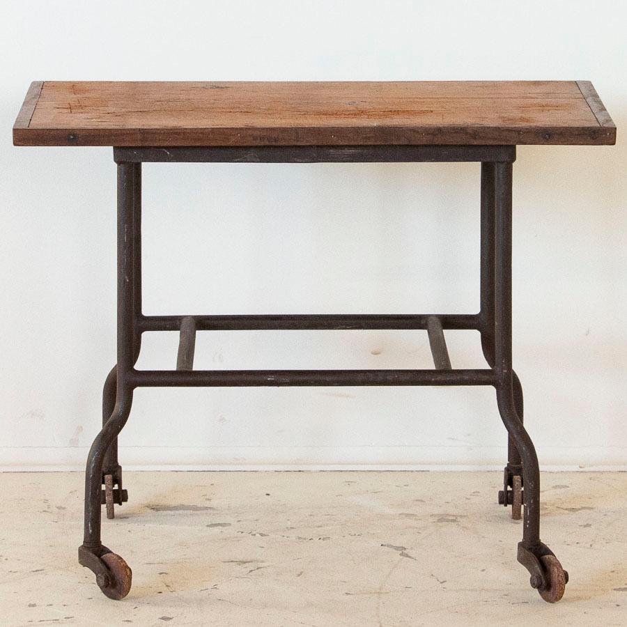 Fun and quirky, this vintage industrial table is all original from the iron base on caster wheels to the rustic wood top. It's small size allows it to be used in virtually any room of ones home, whether for plants, crafts, kids, or any use you