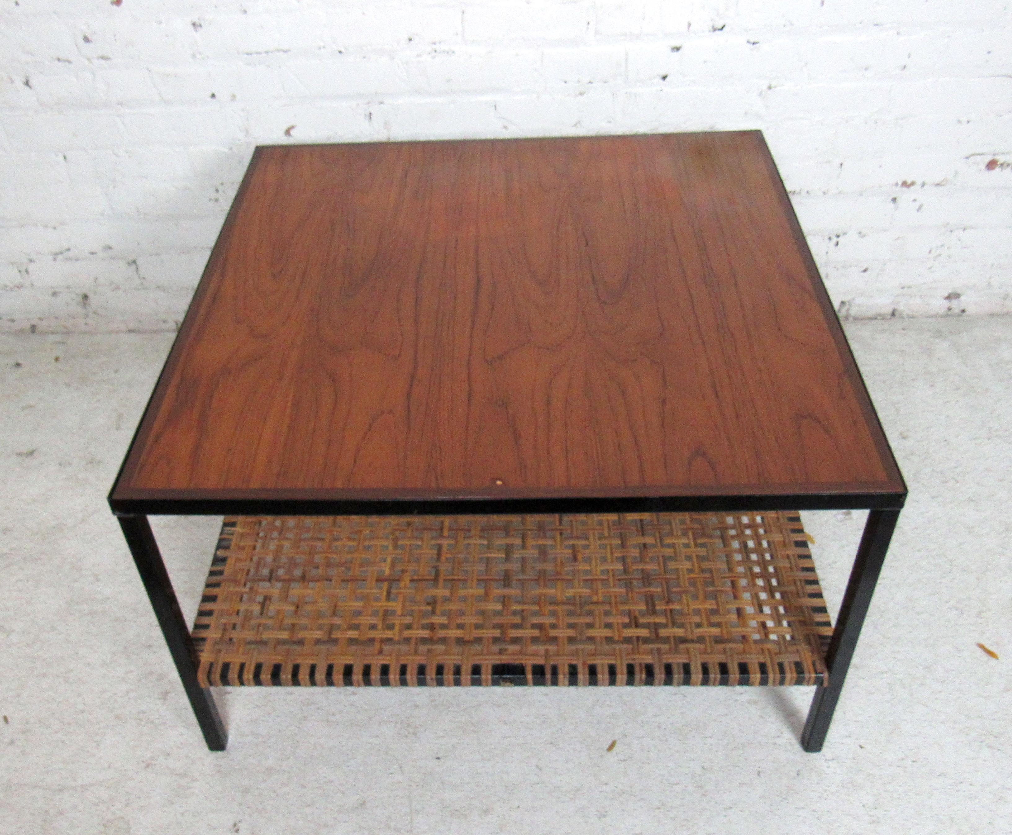 Industrial square coffee table featuring a wooden top tier and wicker bottom tier with a black iron metal frame.

Please confirm item location (NY or NJ).