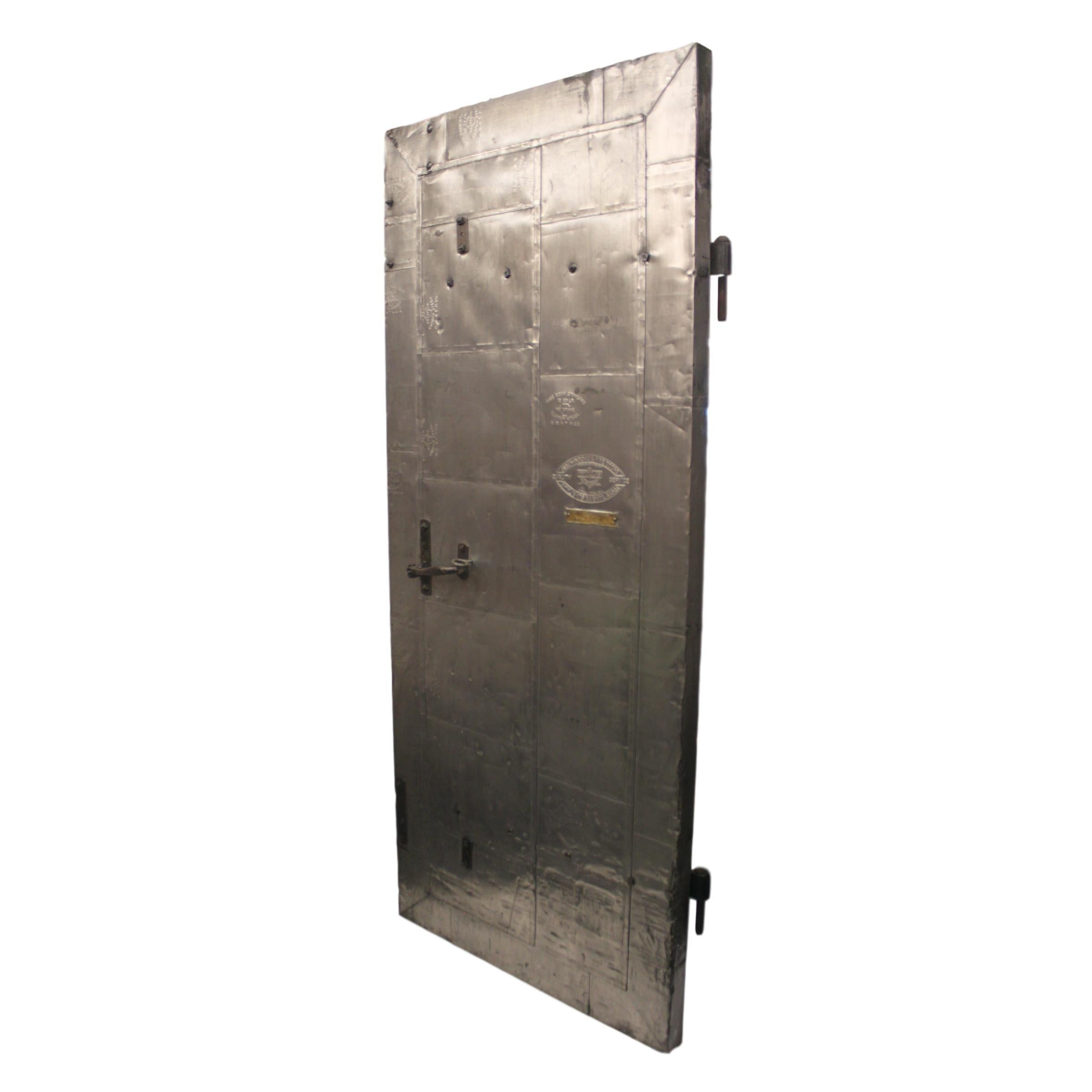 This heavy duty industrial fire door features a solid wood core completely sheathed in individual fire-proof steel-cladding and original hardware. Manufactured circa 1915 by Willis Fire Windows & Fire Doors of Galesburg, IL. Door features an