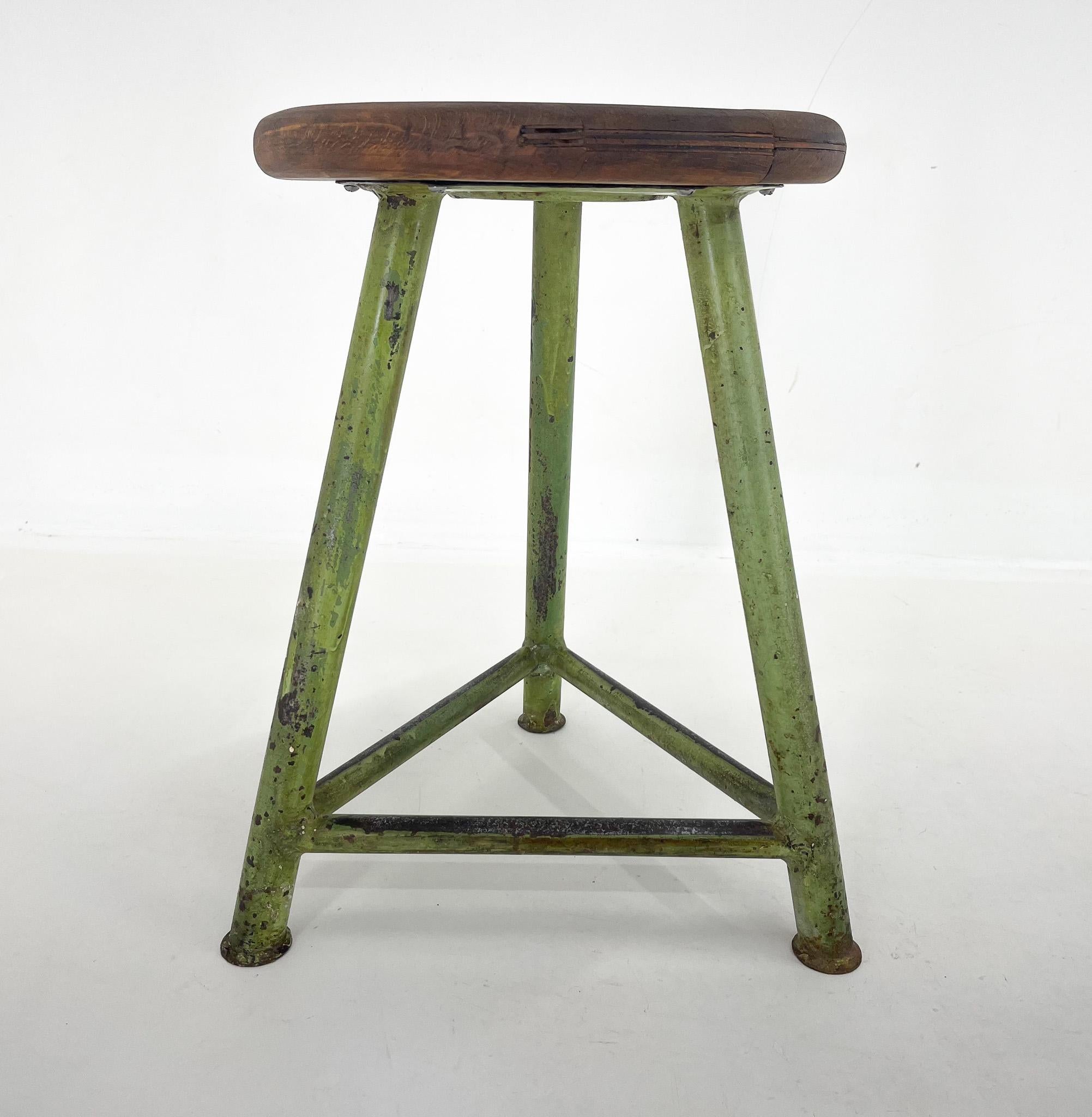 Vintage industrial tripod stool, made of steel and wood. Saved from a factory in former Czechoslovakia. The wooden seat was sanded and treated with a special oil. The diameter of the seat is 34 cm. The widest point at the bottom of the legs is 41 cm.