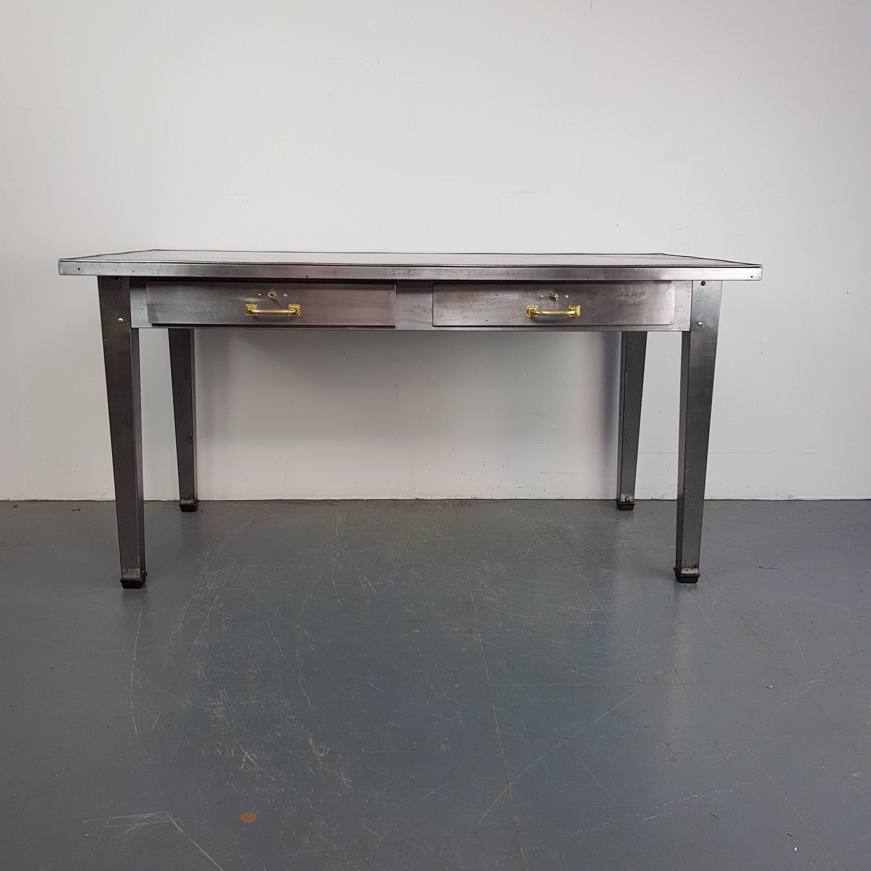 Lovely vintage industrial stripped and polished steel table with drawers with brass handles.

Working lock and key on one drawer.

In good vintage condition - this piece comes from a working industrial environment and so has signs of wear and