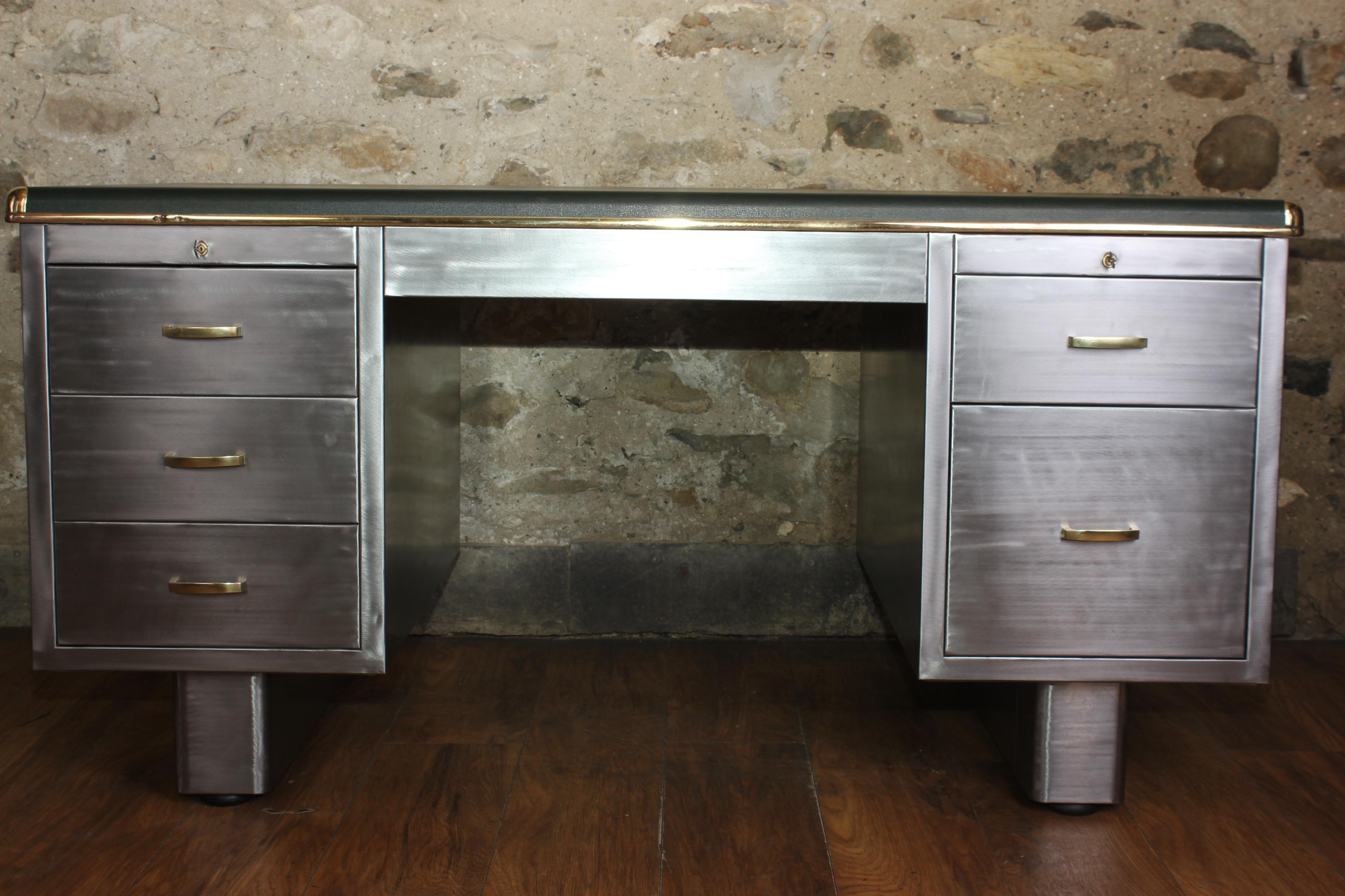 A exceptional vintage English stripped metal tanker desk with solid brass fittings circa 1940s. It has three drawers on one side and two drawers on the other which all run smoothly. It has been stripped back to bare metal on all sides so it can sit