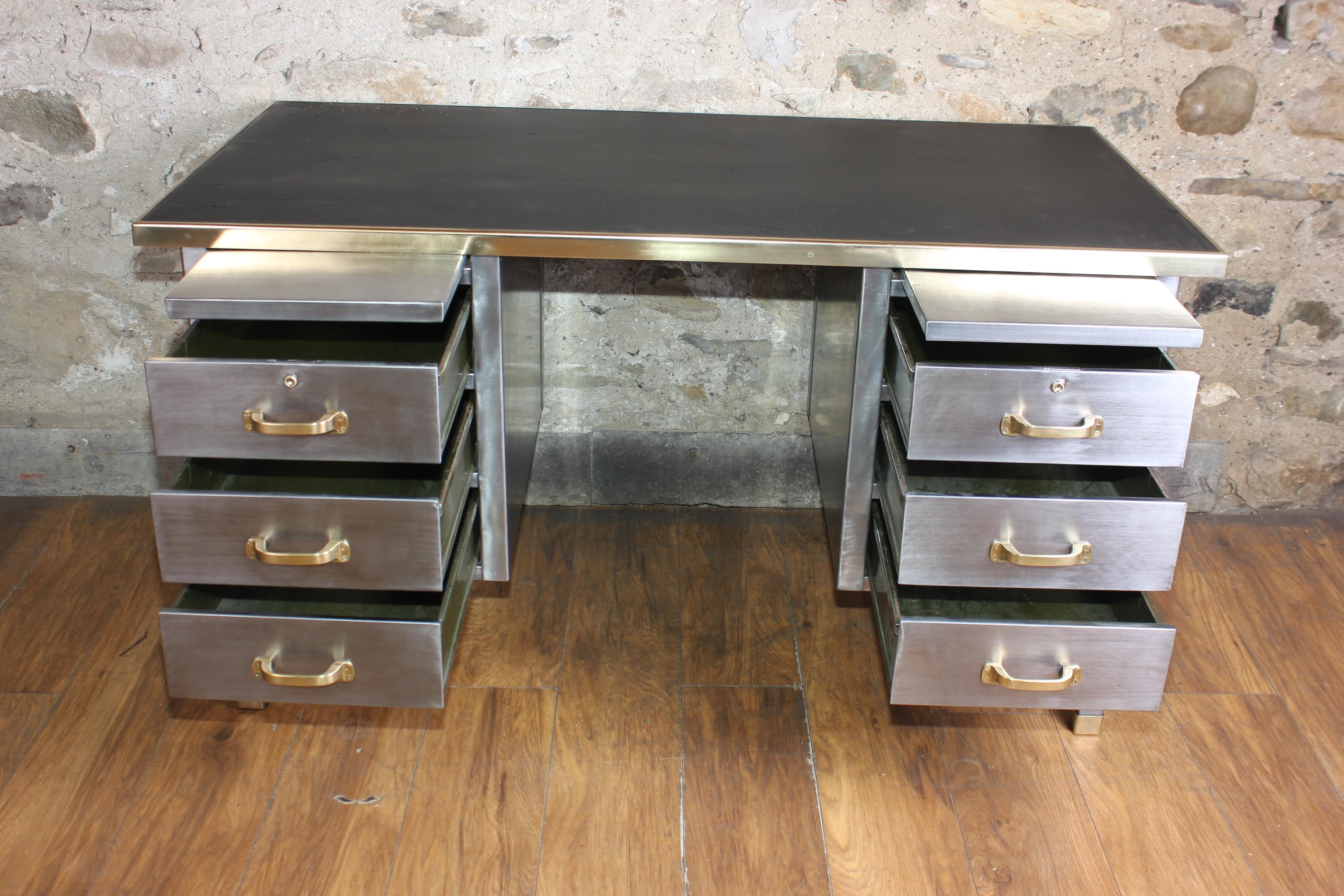 A exceptional vintage English stripped metal tanker desk with solid brass fittings circa 1940s. It has three drawers on either side and 2 pull out shelves which all run smoothly. It has been stripped back to bare metal on all sides so it can sit in