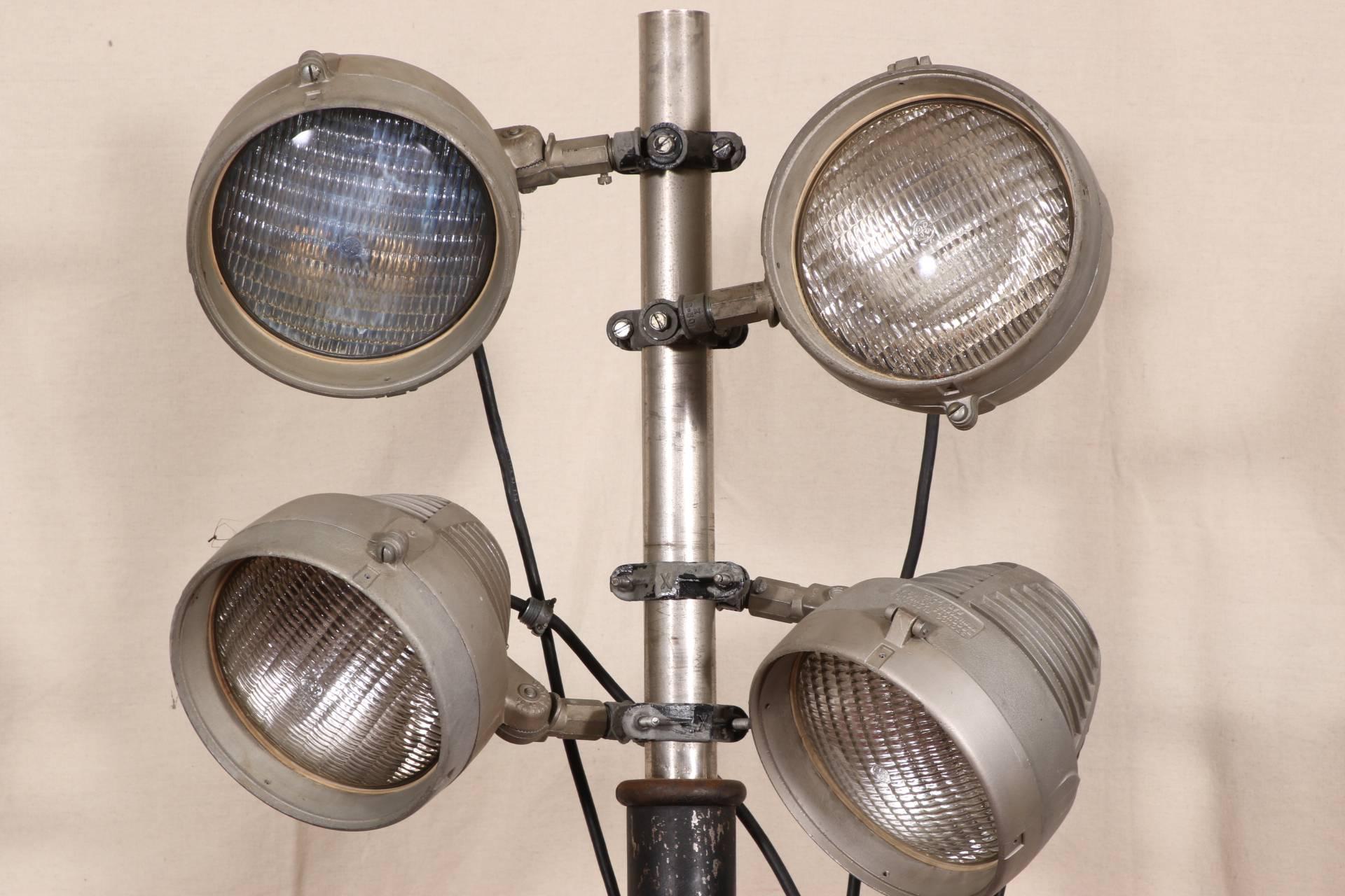 Vintage Industrial Studio Lights by Stongo Electric Products Co., iron tripod base and iron and chrome support with four gray metal adjustable lights- labeled Stongo Electric Products Company Kenilworth NJ, with GE bulbs.

Condition: expected wear