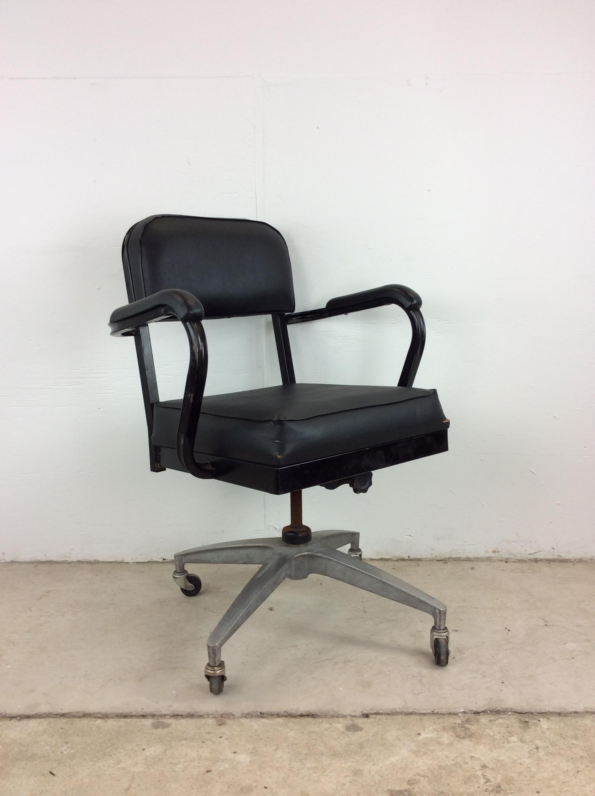 This mid century modern office chair features vintage black vinyl upholstery on seat, back & armrests, black painted metal frame, and wheeled base. This chair gives off serious authentic Madmen vibes while also being a comfortable place to get work