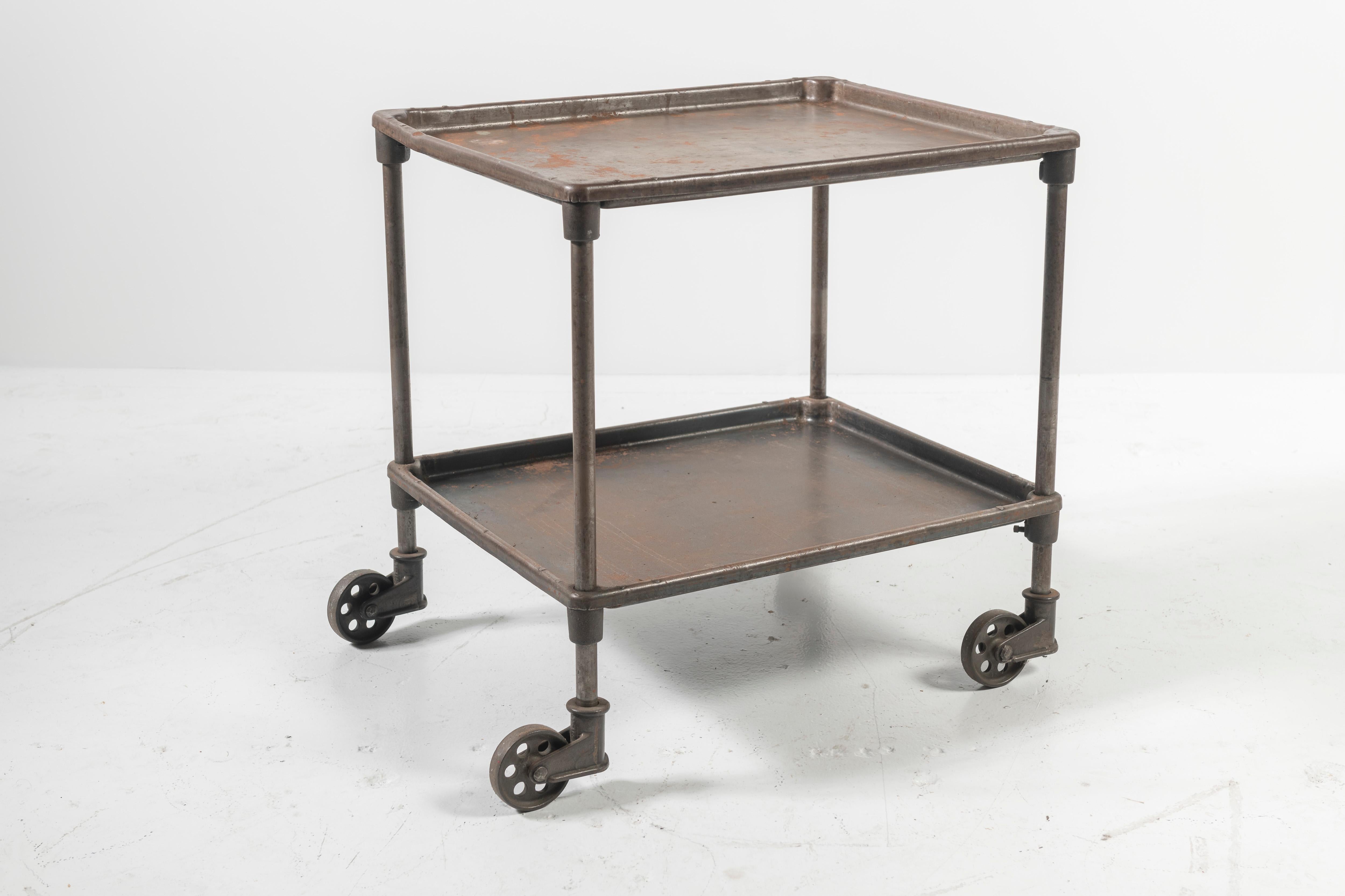 Vintage industrial machinist cart on wheels. All the metal has an aged patina. Wheels easily to where you need it, such as a bar cart.
