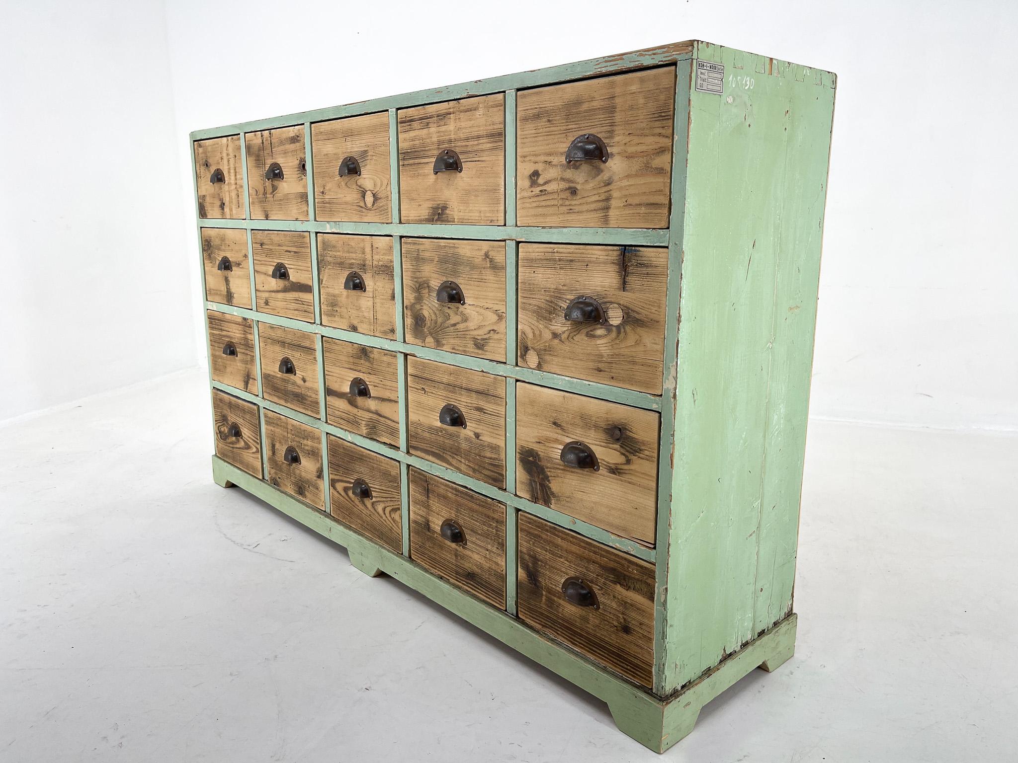 Amazing industrial wooden cabinet with 20 drawers with original metal handles. This vintage filling cabinet was rescued from the famous KOH-I-NOOR factory in former Czechoslovakia. You can find the mark on the side of the cabinet. Some of the drawer