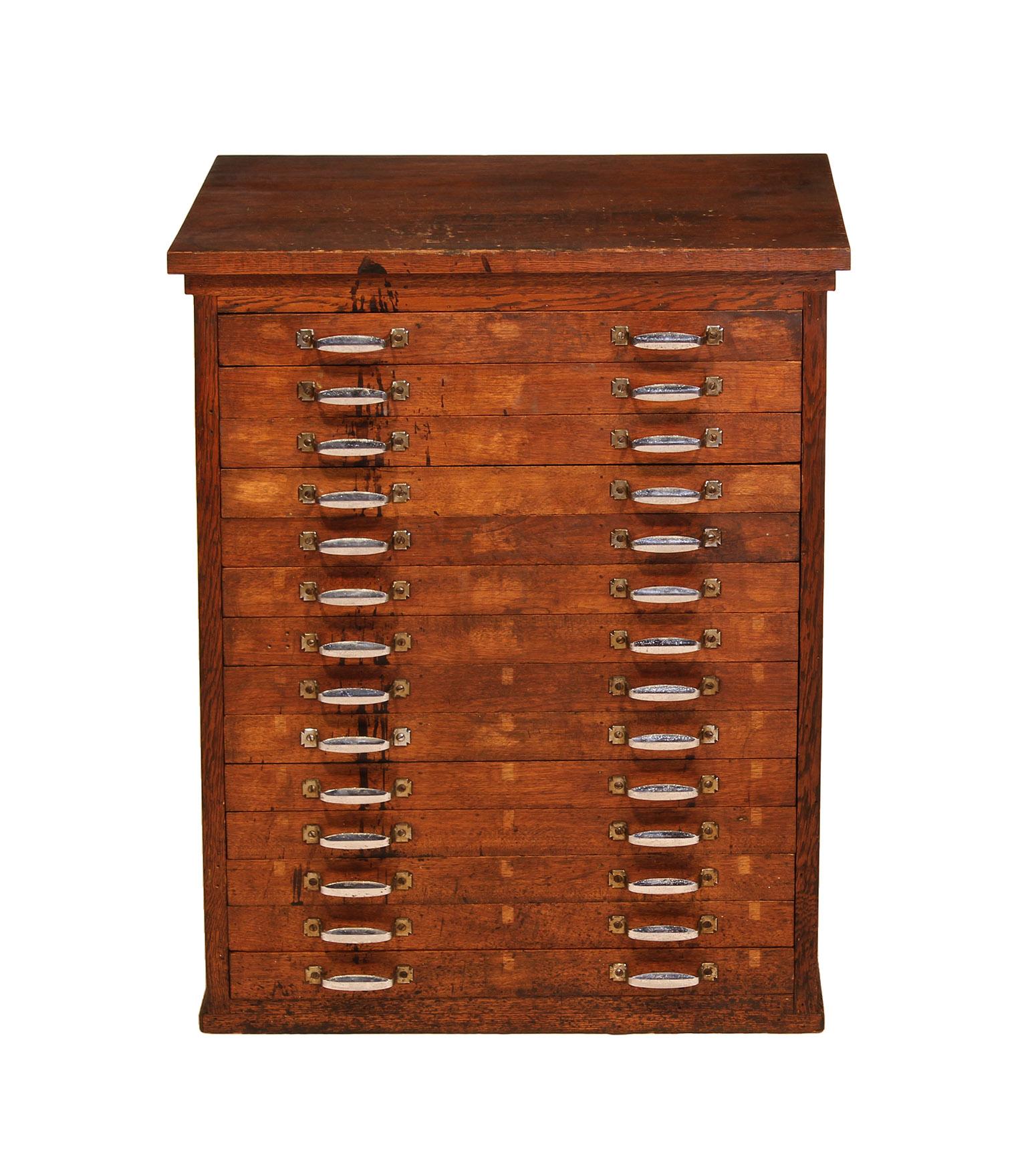 Authentic vintage industrial jewelers / machinists / apothecary storage cabinet. Beautifully aged oak wood cabinet with worn chromed steel handles. Cabinet is finished and paneled all the way around and features fourteen drawers, each with three