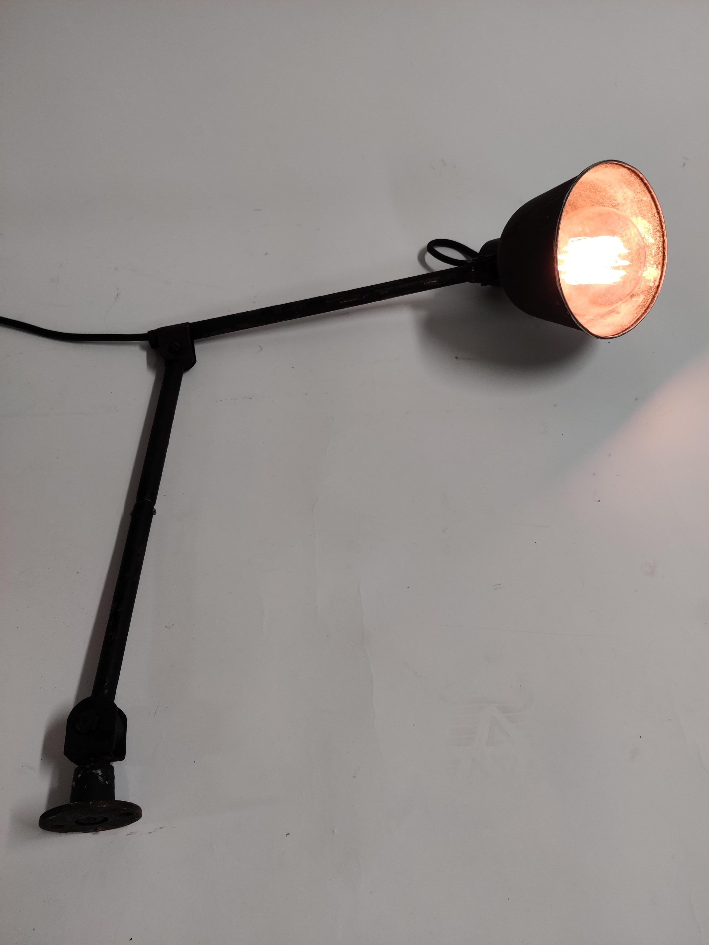 Vintage industrial work light or machinist lamp.

This articulated desk lamp is made of metal and has and adjustable lamp shade.

It can be mounted directly onto a work bench or on a metal or wooden base.

1950s,