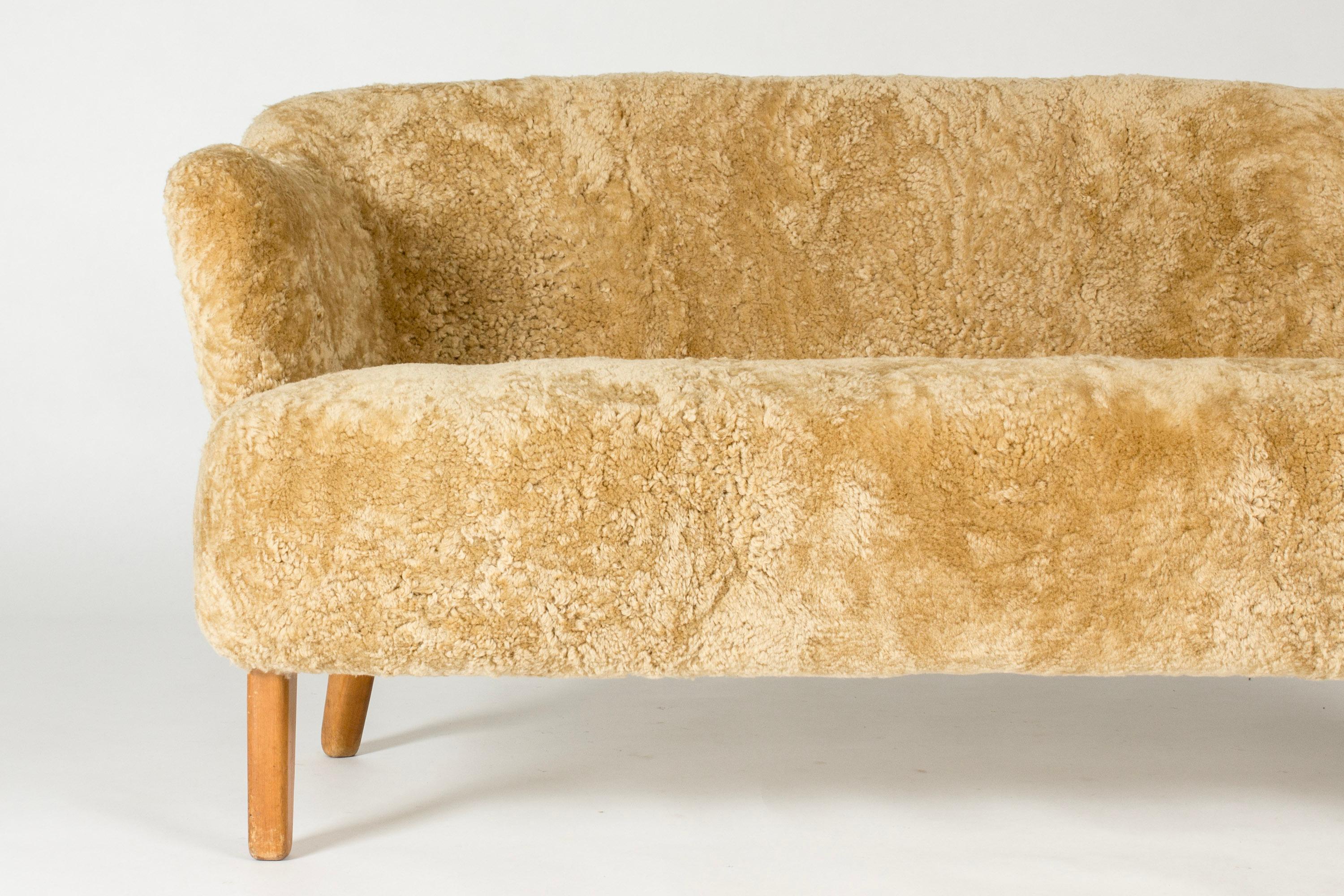 Beautiful “Ingeborg” sofa by Flemming Lassen, with curvesome forms. Designed in 1940 and named after his mother, the artist Ingeborg Winding. Upholstered with caramel colored sheepskin, birch legs.