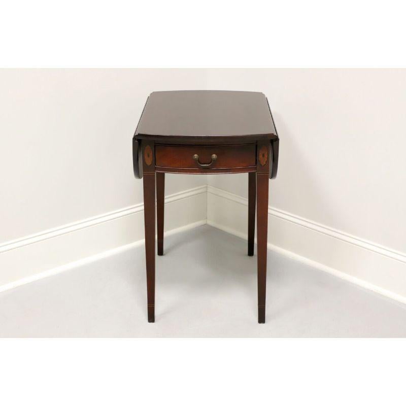 A Hepplewhite style inlaid mahogany pembroke table, unbranded, similar in quality to Drexel and Hickory Furniture. One drawer of dovetail construction and brass hardware. Inlaid details. Made in the USA in the mid 20th Century.

Measures: 19 W 28 D