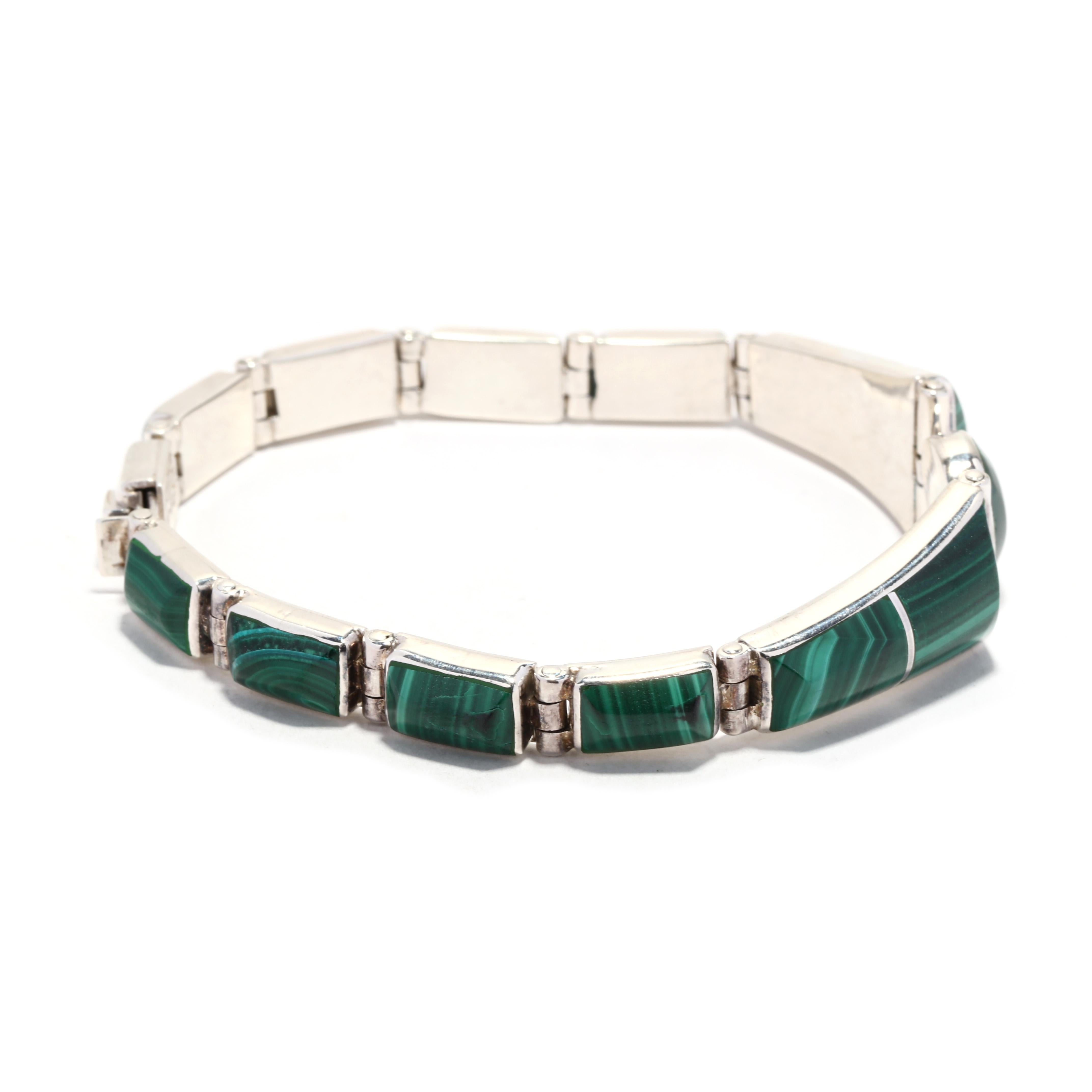 This Vintage Inlaid Malachite Bracelet is made from sterling silver and is 7.5 inches in length. It features elaborately inlaid Malachite in a unique and eye-catching design. This stunning piece of Mexican silver jewelry will add an exquisite and