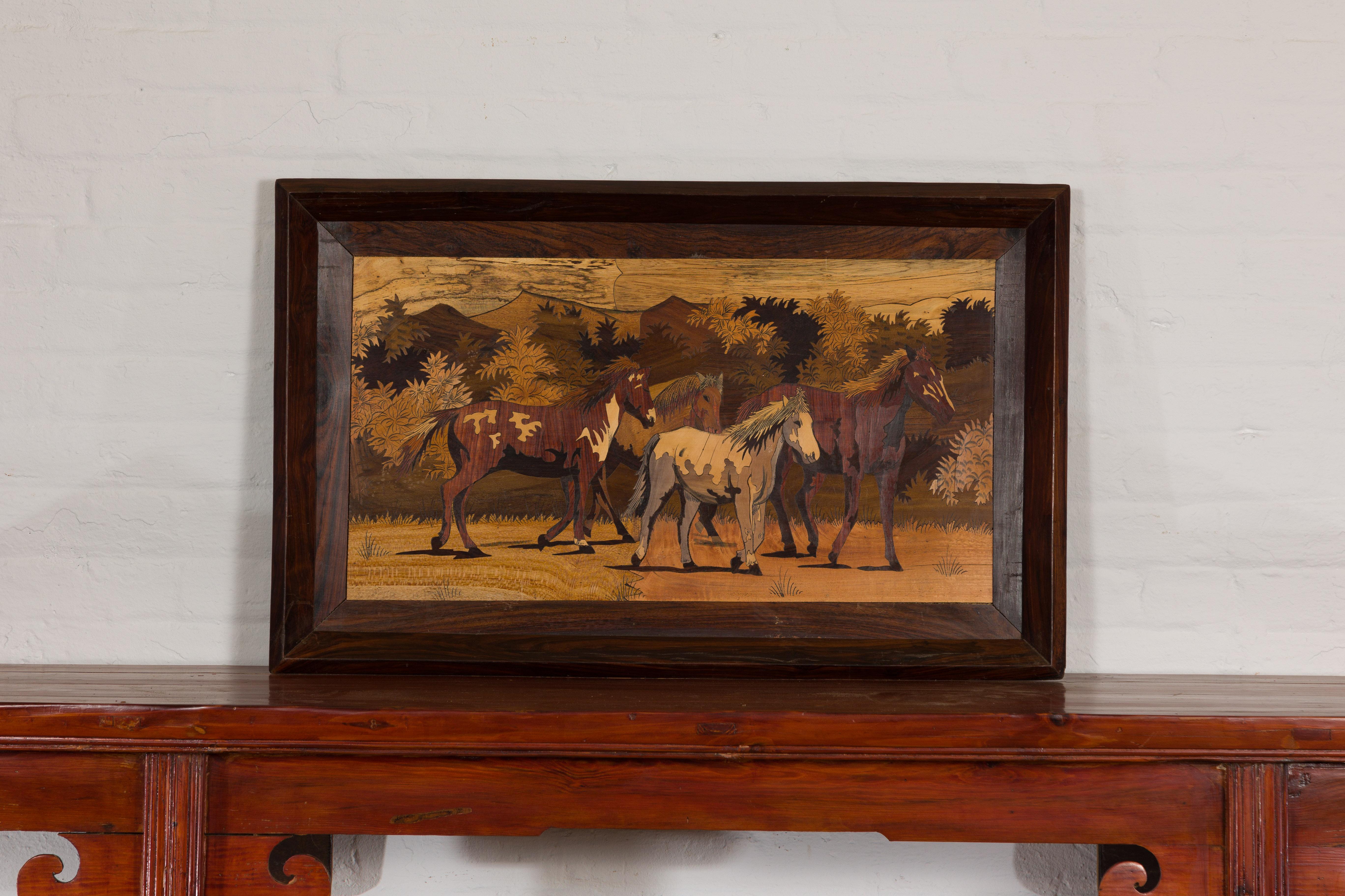 A vintage framed inlaid wood painting depicting four horses in a landscape in simple wooden frame. Experience the timeless beauty of this vintage framed inlaid wood painting. This captivating piece, illustrating four horses in a serene landscape, is