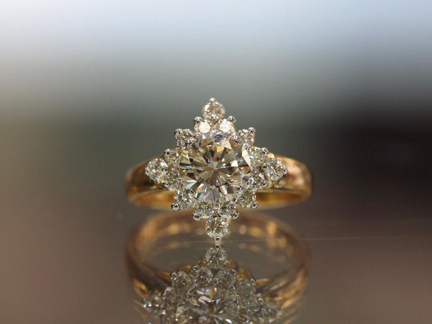 This stunning vintage diamond ring has the perfect starburst design surrounding a 1.16CT round brilliant diamond center that is J color, SI2 Clarity. (6.78mm X 6.82mm)The inclusion in the center stone is white and sitting right next to a prong