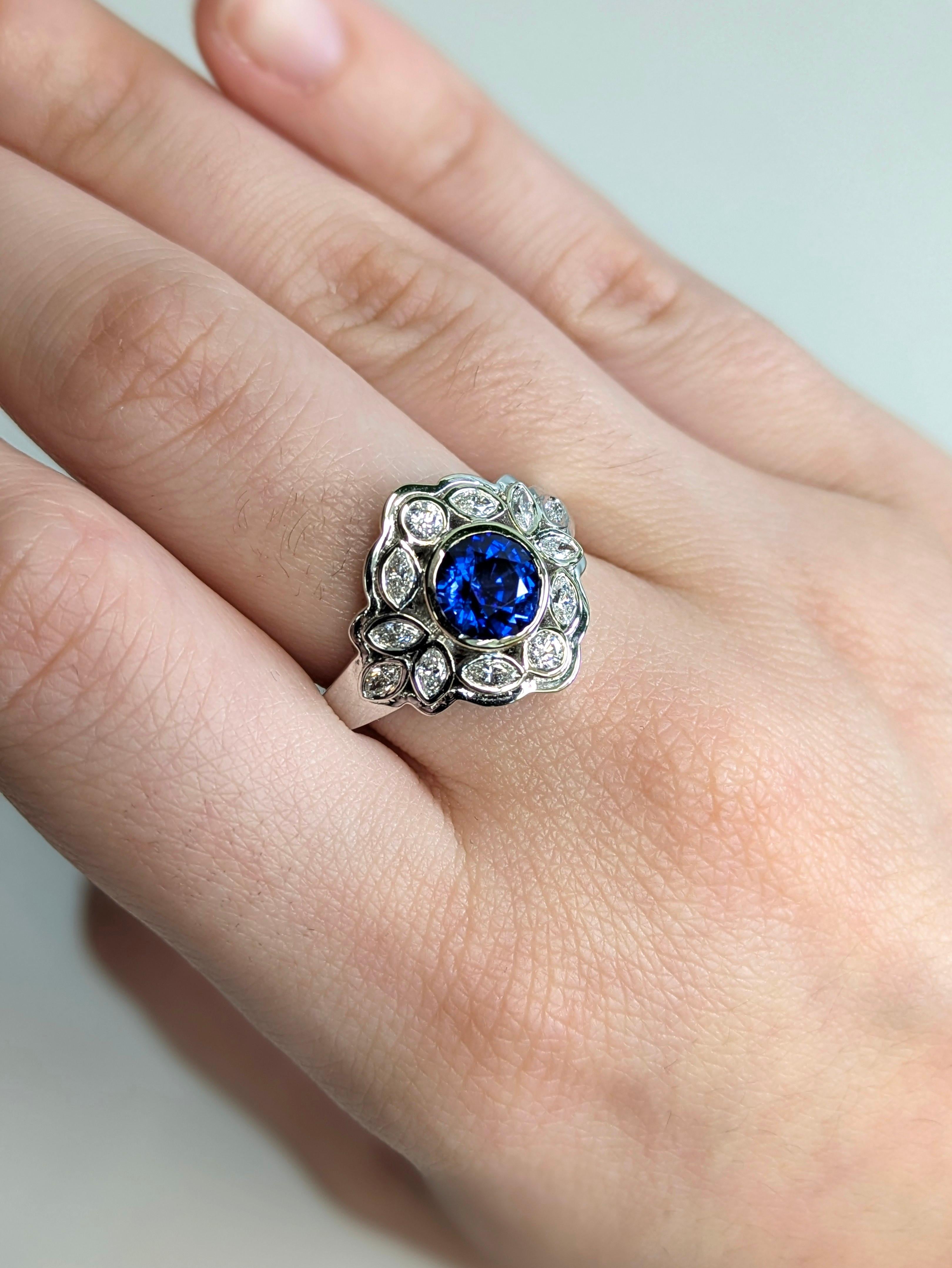 This dazzling 2.13-carat Ceylon sapphire ring brings vintage drama with its elegant bezel setting, ornate marquise and round diamond surround, and polished white gold frame. Because some rings are born to be passed down.

