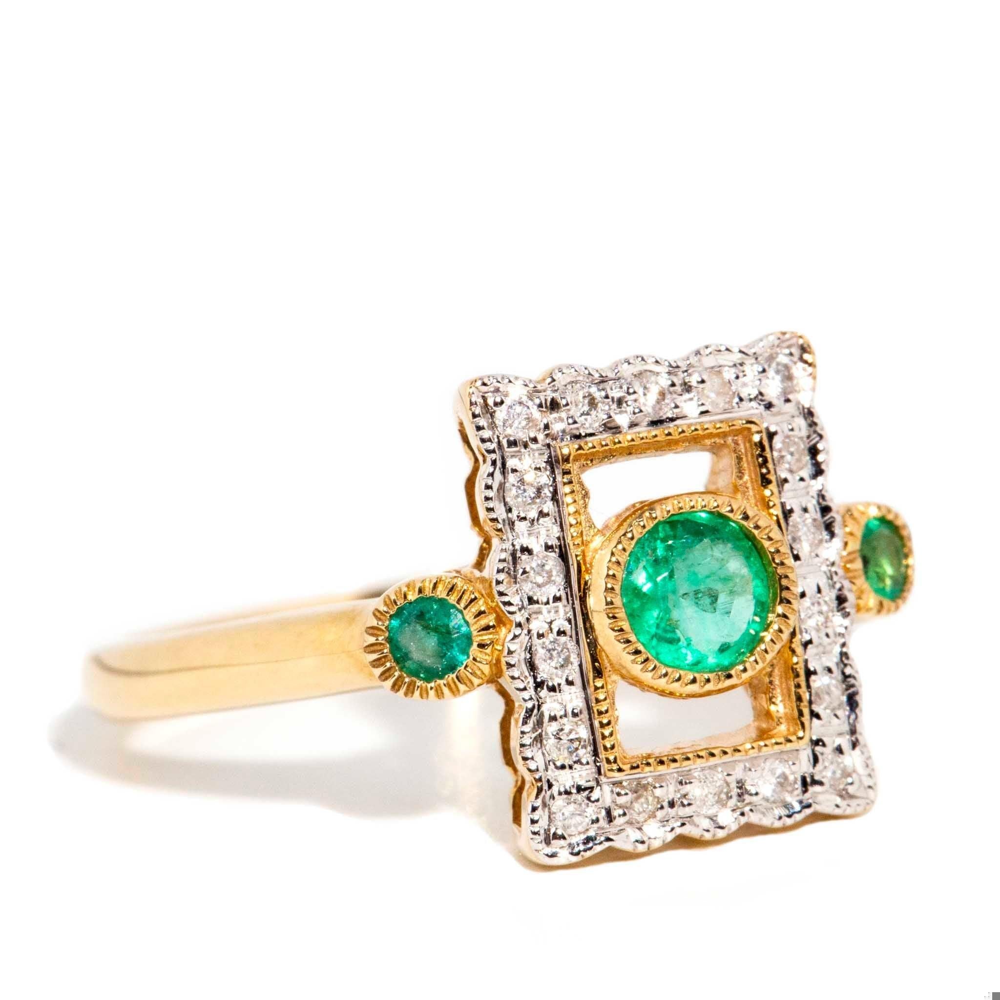 A delicate lace frame of diamond embellished gold presents a gorgeous emerald that shines bright with intensity matched only by the emeralds buttressed at her side. She is the 9 carat gold Francie Ring, made to capture the profound sweet fragility