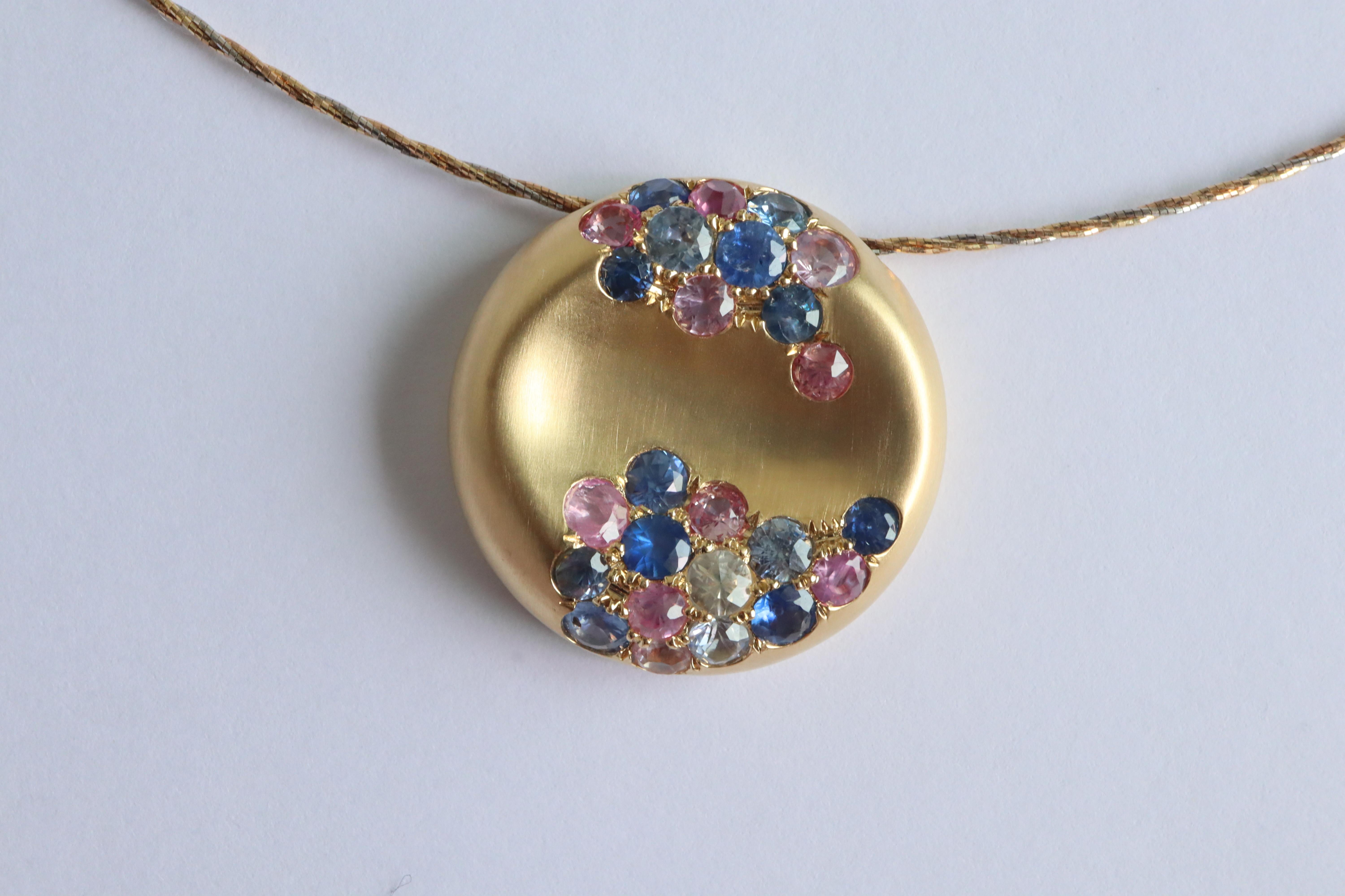 Ce pendentif contemporain en saphir est orné de saphirs birmans non chauffés de différentes couleurs, rehaussant son aspect doux et unique. Il présente des bords arrondis, une finition brossée mate d'inspiration vintage et un design coulissant,