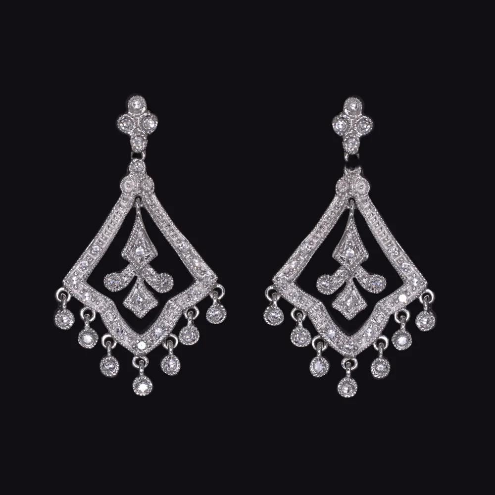 These captivating diamond chandelier earrings combine vintage charm with refined elegance. Crafted in 14k white gold, their graceful scalloped silhouette is enhanced by delicate diamond accents that shimmer with movement.

Set with 0.50 carats of