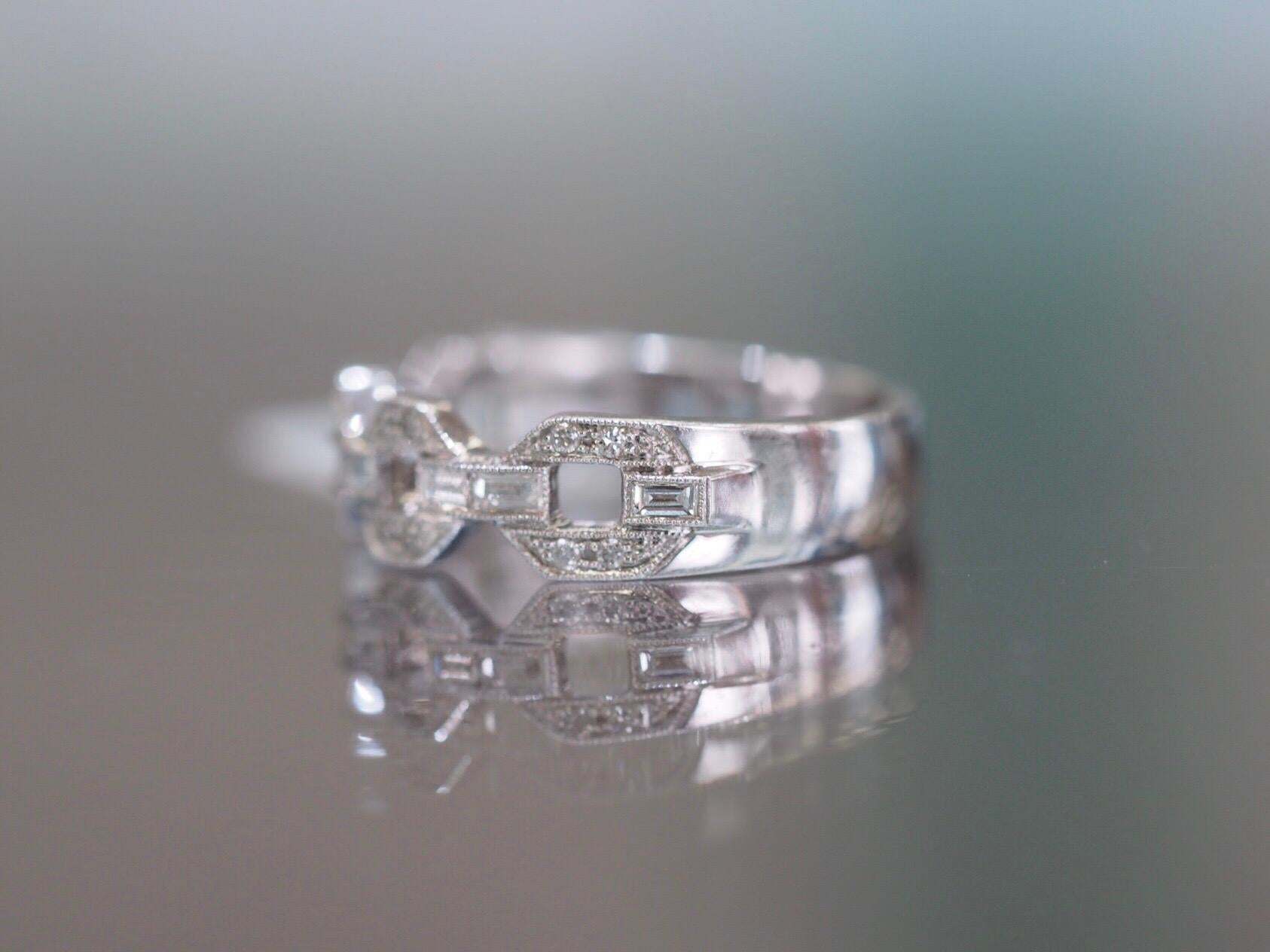 This 18k white gold band features four hexagon silhouettes with melee diamonds and connecting pairs of baguette diamonds with a milgrain edging giving it the perfect modern day vintage look. It has 0.35ctw of round brilliant cut diamonds and emerald