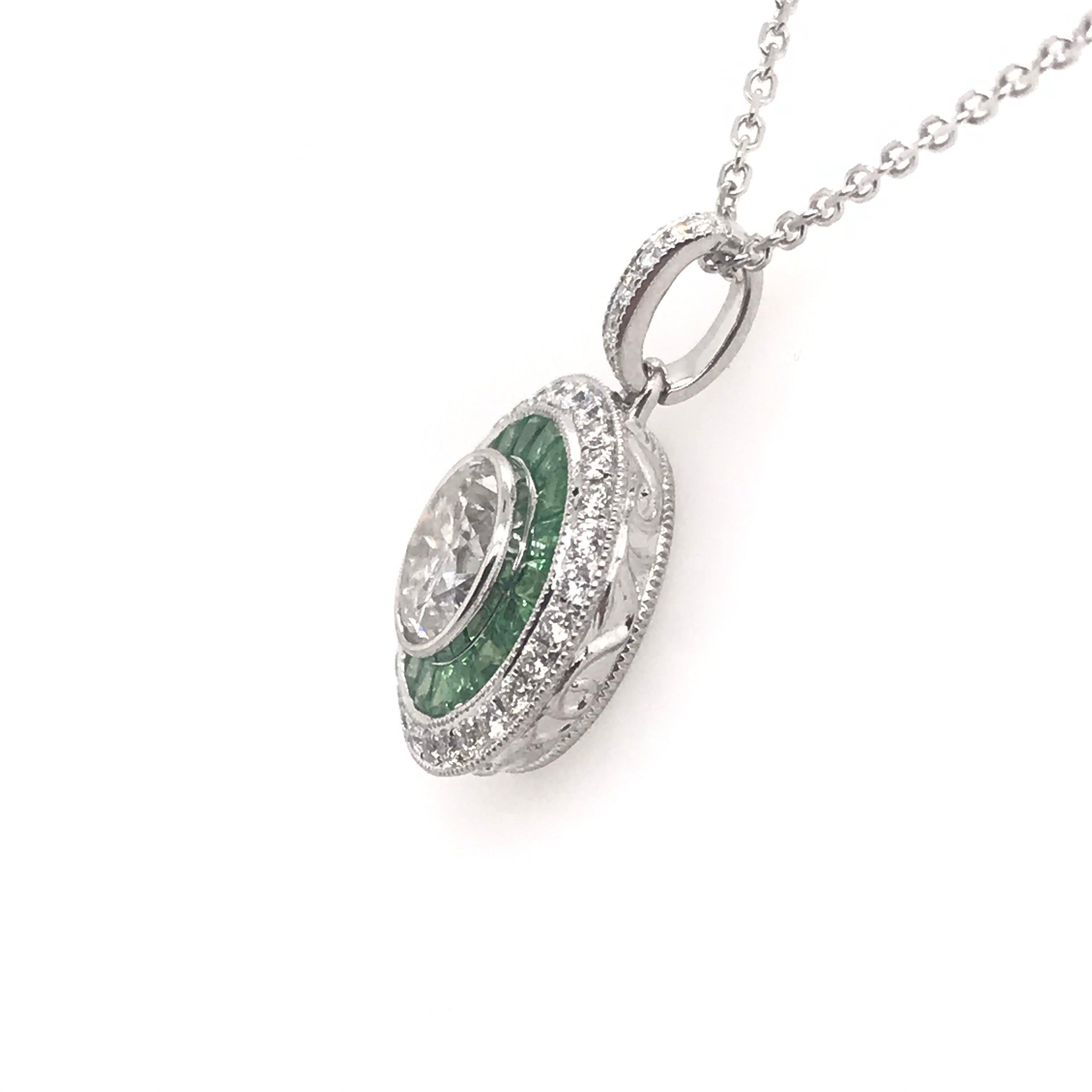 We love this antique reproduction style!

Crafted in 18K White gold, the beautiful pendant features a gorgeous 0.98 Carat Round Diamond, H Color I1 Clarity. Accenting the center stone are numerous french cut Tsavorite garnets and round diamonds.

We