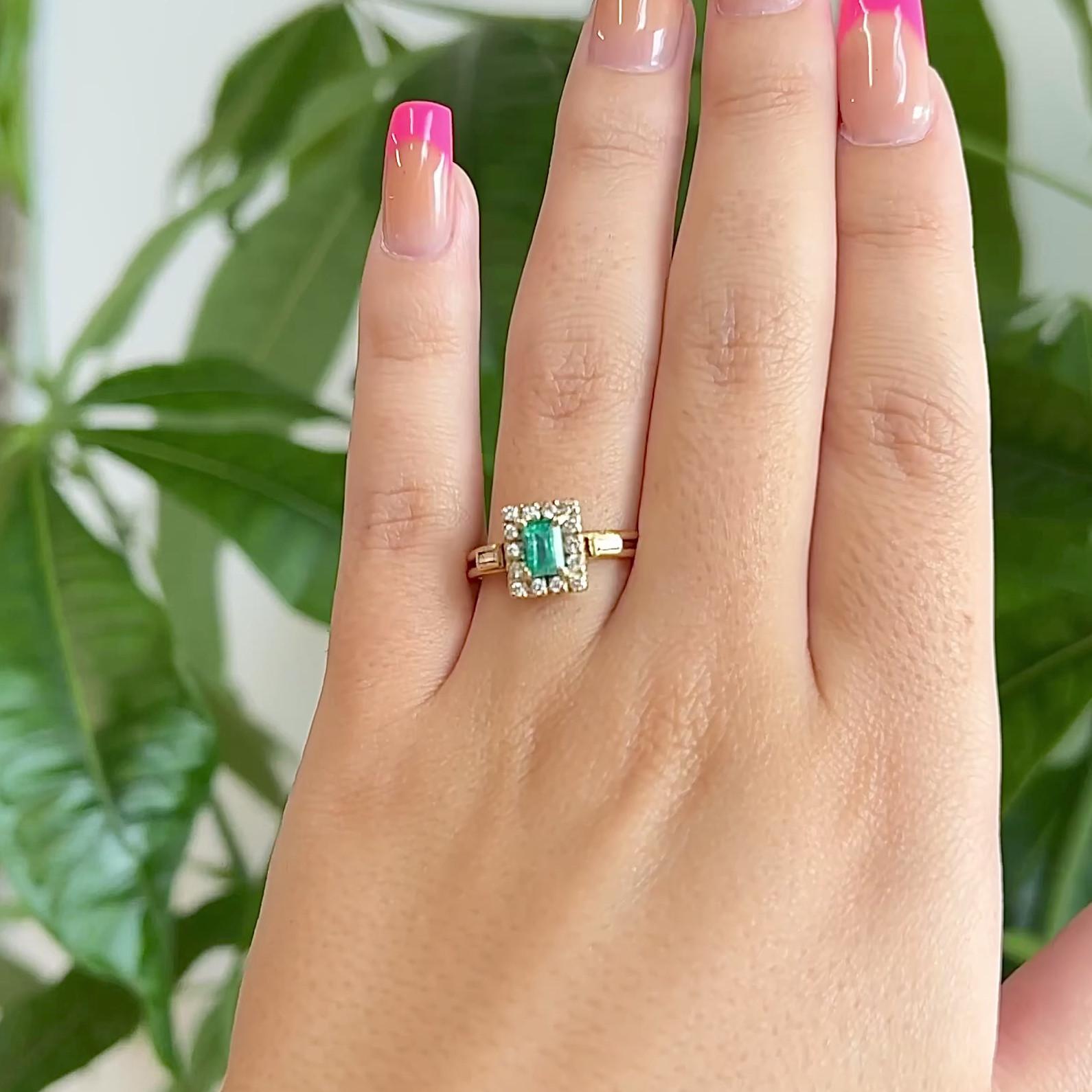 Ein Vintage Smaragd Diamant Gelbgold Ring. Mit einem rechteckigen Smaragd im Stufenschliff von etwa 0,50 Karat. Akzentuiert durch 14 runde Diamanten im Brillantschliff mit einem Gesamtgewicht von ca. 0,20 Karat, eingestuft in Farbe F, Reinheit