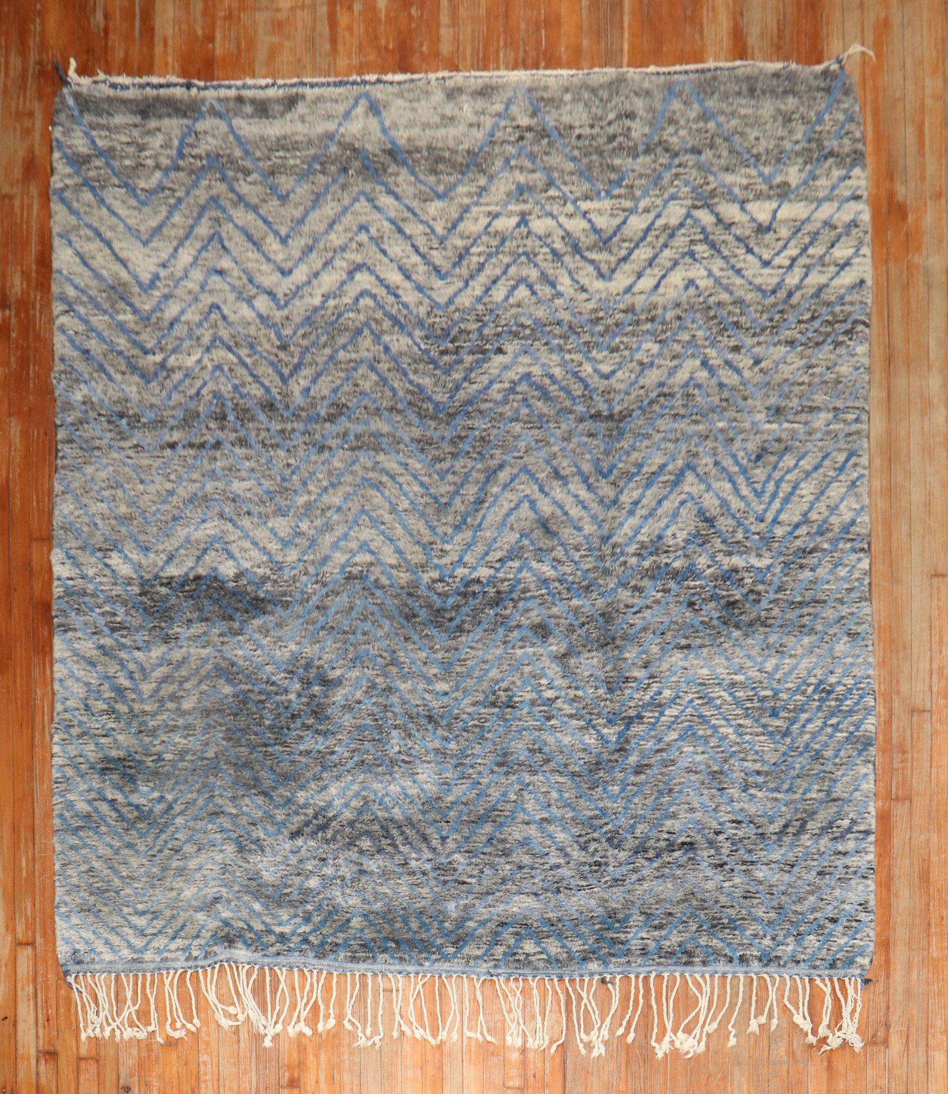 An early 21st Century Moroccan rug in gray and blue. The wool is lustrous and soft and cozy on the feet

Measures: 7'6'' x 9'6''.