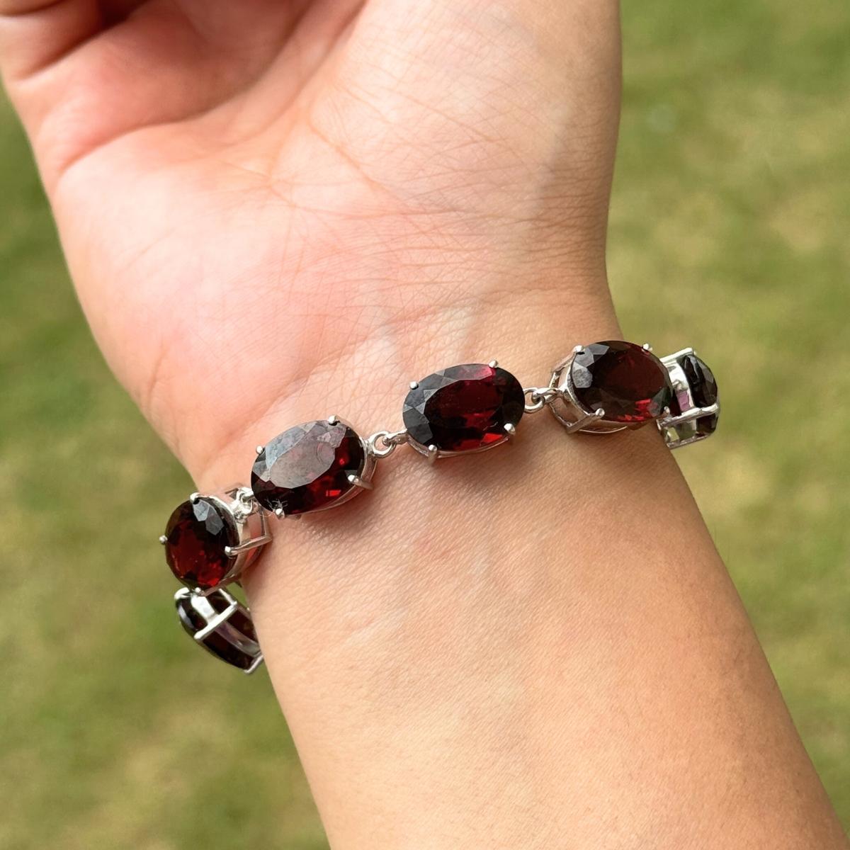 Questo bracciale bolo regolabile con granato rosso da 34,69 CTW è un bracciale bolo di grande effetto, meticolosamente realizzato a mano in argento sterling 925 e impreziosito da sette gemme ovali sfaccettate di granato rosso intenso. Ogni granato è
