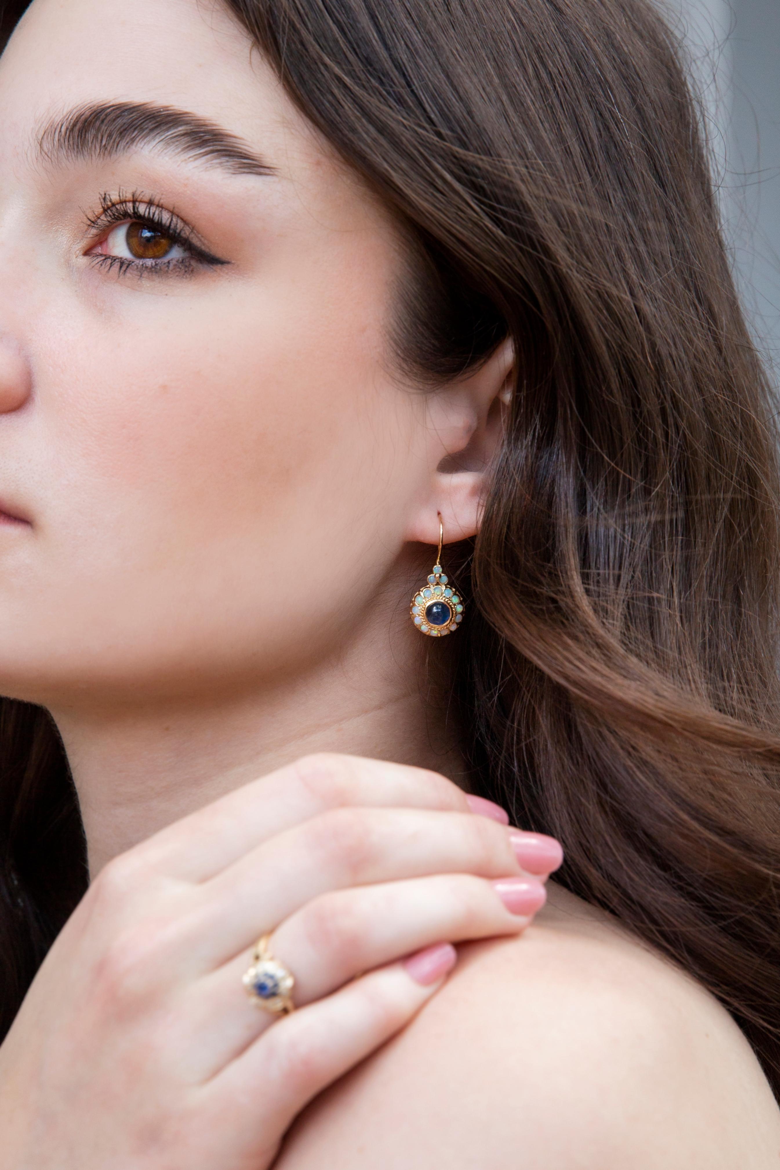 The Etta Earrings are a rich fusion of bright blue sapphires and radiant opals, wrapped in gold and presenting as darling daisies. A wonderful celebration of natures whimsy that will journey with you and yours through the years.

The Etta Earrings