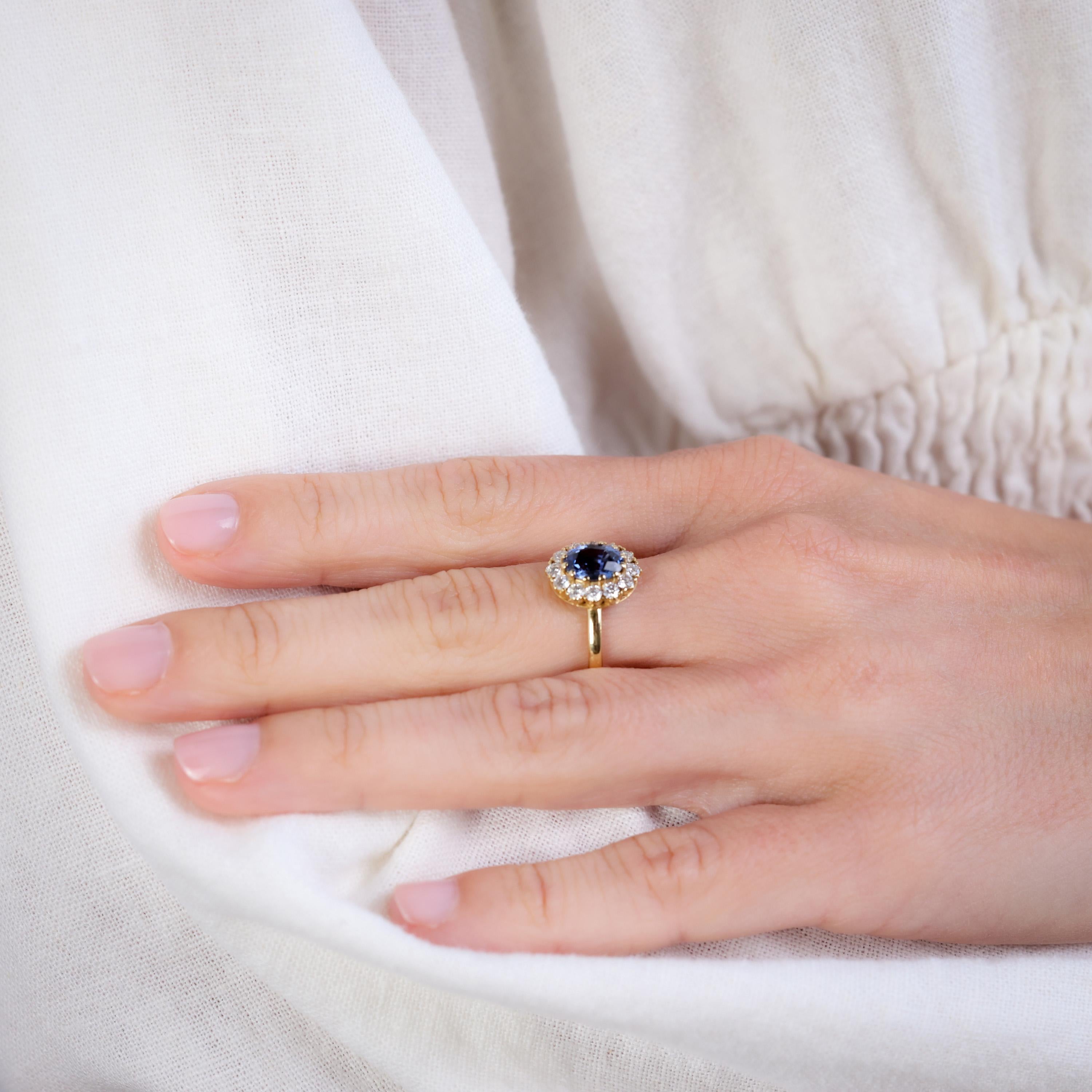 Center Stone: Sapphire
Cut: Oval 
Weight: Approximately 1 Carats
Color: Blue
Accent Stone: 12 Diamonds
Cut: Round Brilliant
Weight: Approximately 0.60 Carats
Color: G
Clarity: SI
Metal: 18K Yellow Gold
Era: Vintage Inspired
Circa: 2020s
Hallmarks: