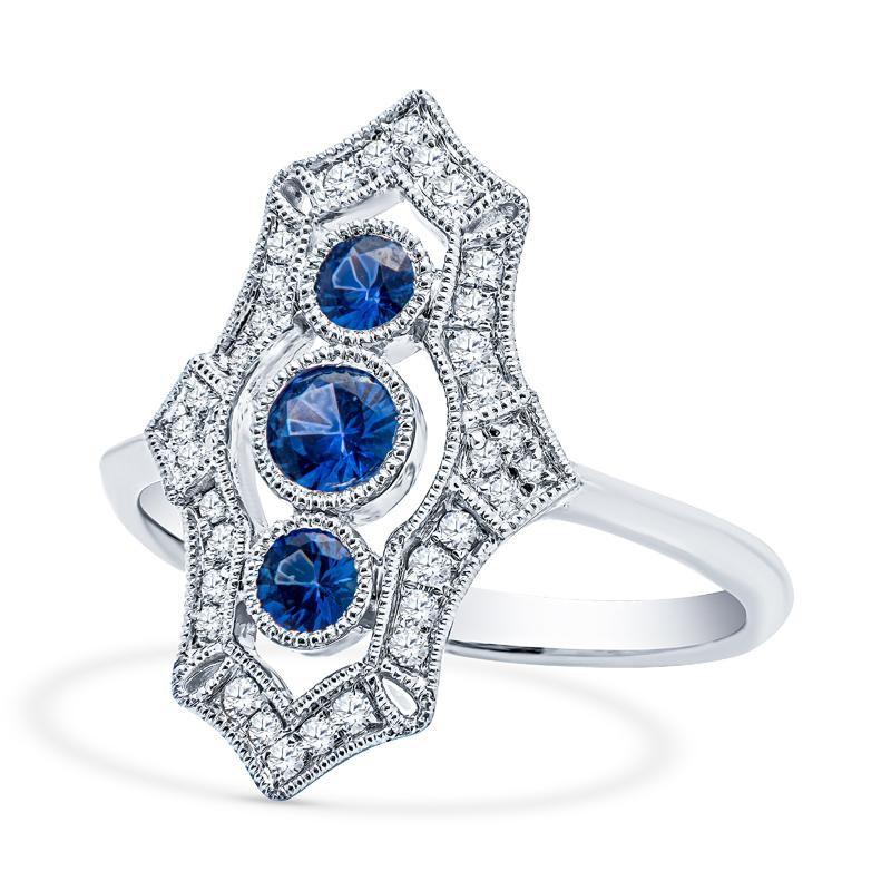 This vintage inspired ring features 0.40 carat total weight in round blue sapphires and 0.25 carat total weight in round diamonds set in 18 karat white gold. This ring is a size 4.75 
Measurements: Approximately 19.25mm x 12.20mm